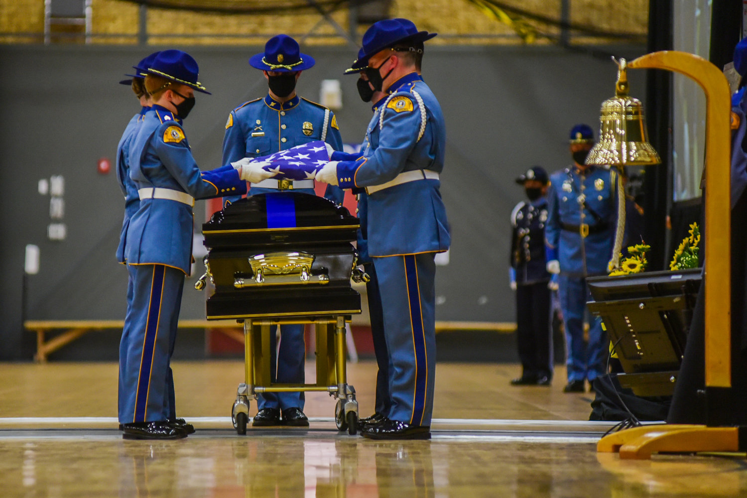 Members of the Washington State Patrol fold a flag over the casket for fallen trooper Justin R. Schaffer Wednesday afternoon in Centralia.