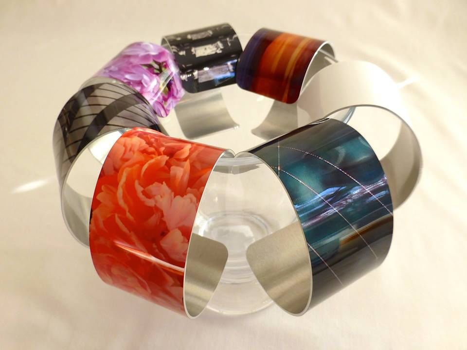 Pictured is a collection of bracelets with images taken and edited by Nancy Jacobson.