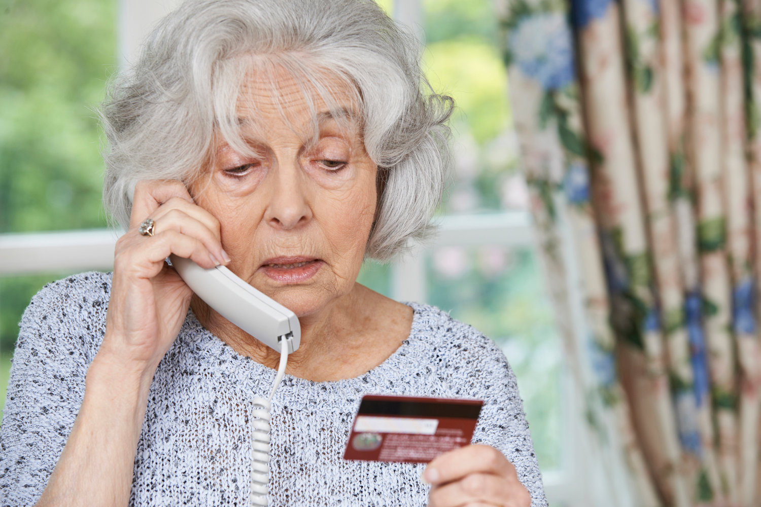 Senior Woman Giving Credit Card Details On The Phone