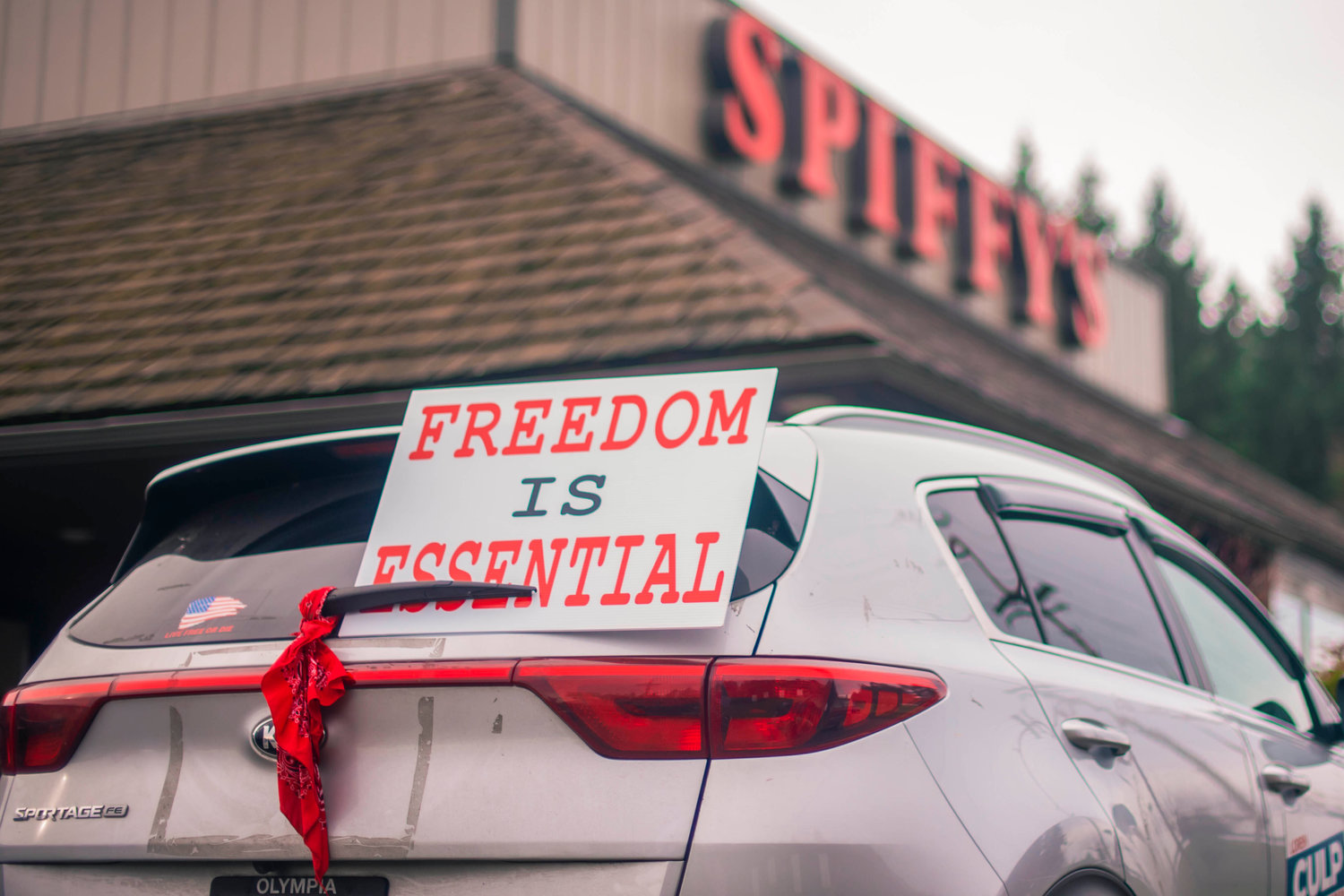 A sign is displayed on a car outside of Spiffy’s reading, ‘Freedom Is Essential’ as the restaurant continues to host indoor dining on Thursday in Chehalis.