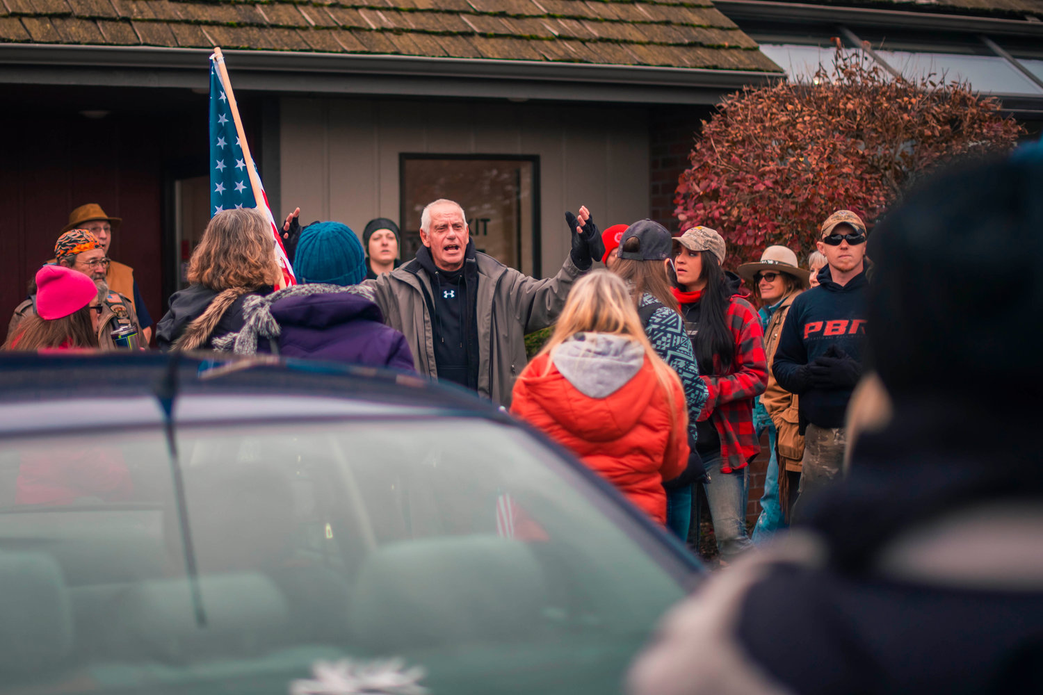 Crowds congregate near the enterance of Spiffy’s some holding flags during ‘peaceful protests’ on Thursday in Chehalis.