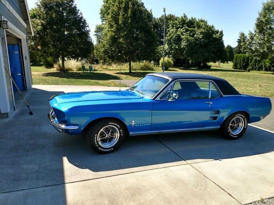 Patrick Murphy shows off his wife’s shiny, blue 1967 Ford Mustang.