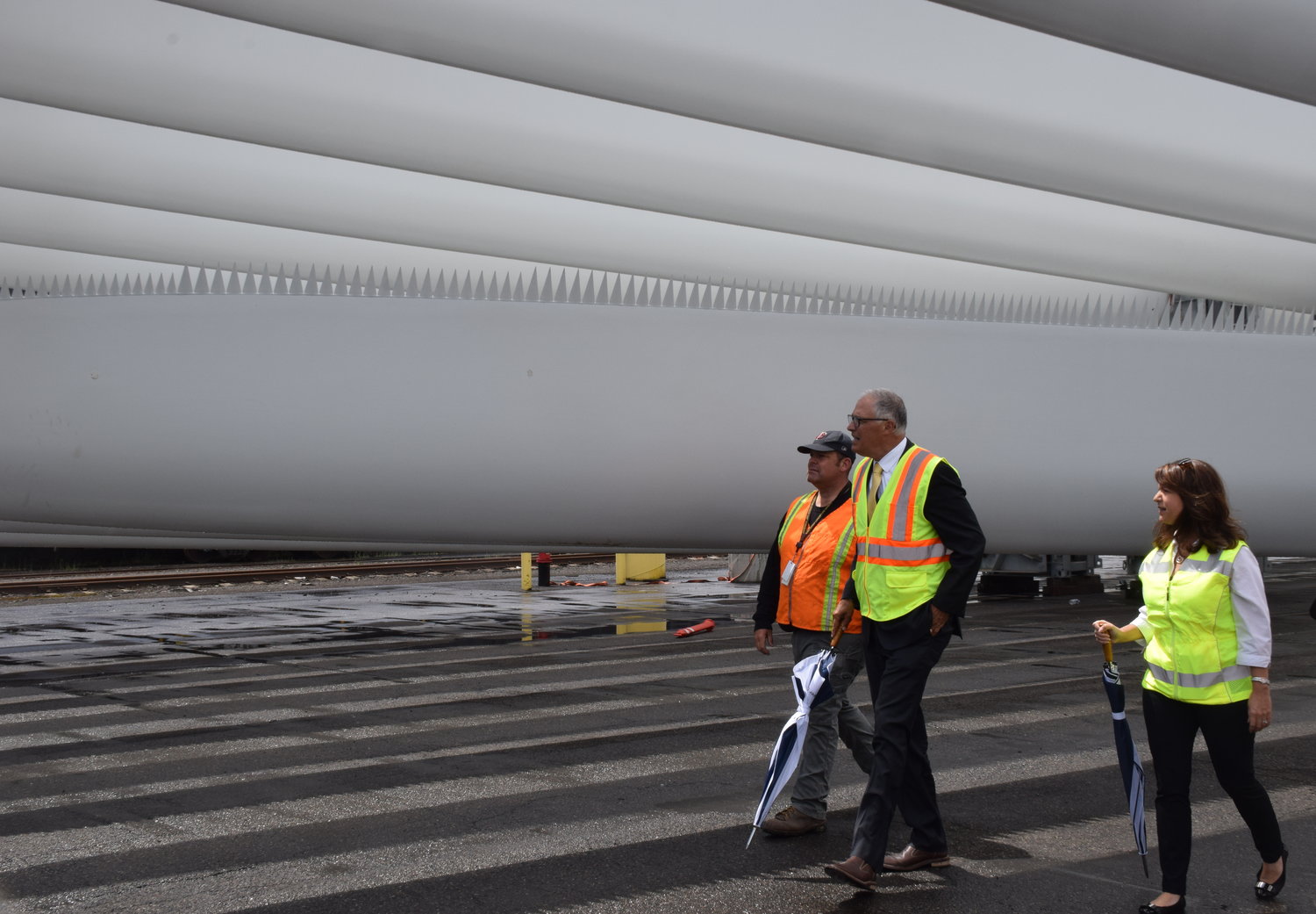 Gov. Jay Inslee, center, tours a Port of Vancouver terminal housing wind turbine blades that will be shipped to an energy project in Wasco, Oregon, alongside ILWU Local 4 President Cager Clabaugh and Port of Vancouver CEO Julianna Marler on June 15. 