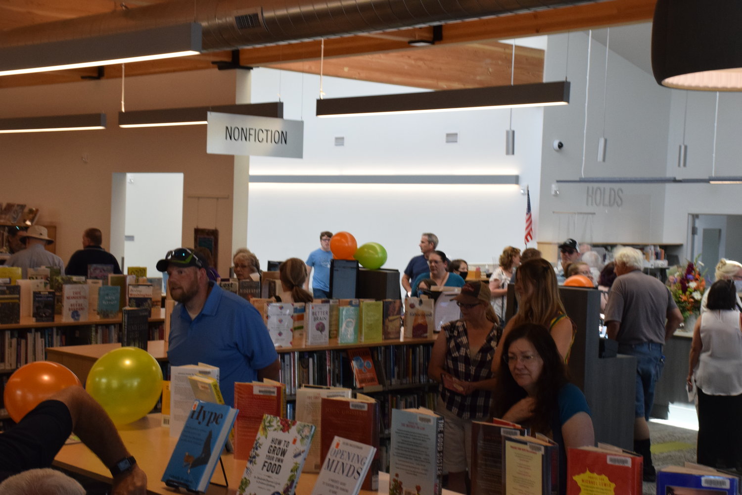 The first members of the public browse the adult section of the Ridgefield Community Library during its grand opening on July 9.