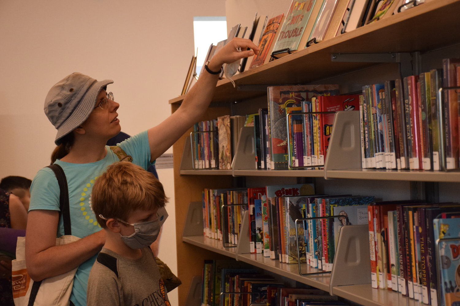 Margaret Christensen and her nephew, Finn, look through the children’s section of the Ridgefield Community Library during its grand opening on July 9.