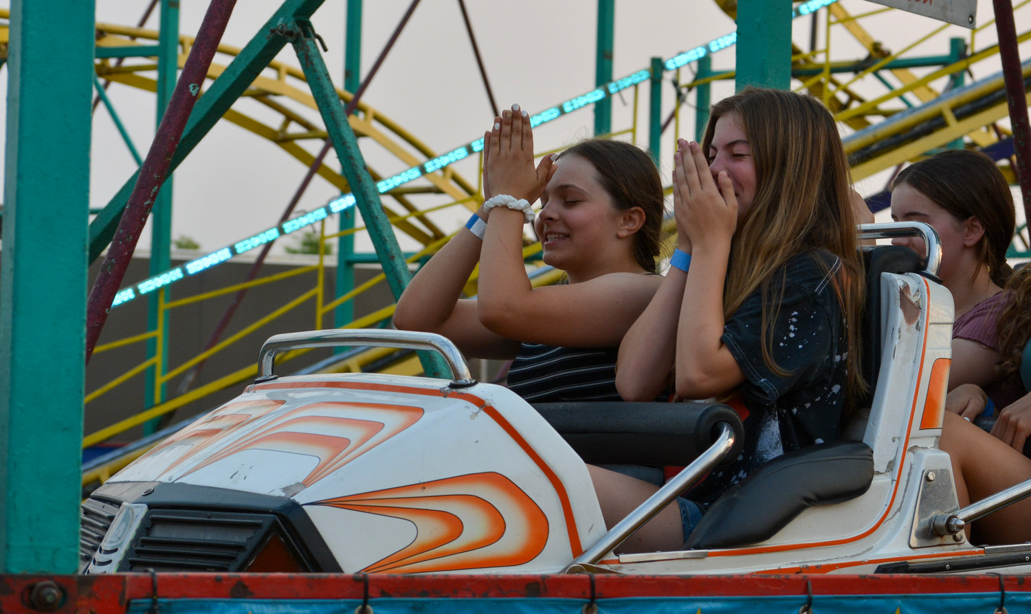 Attendees sit in an amusement park ride during the Family Fun Series event on Aug. 13.