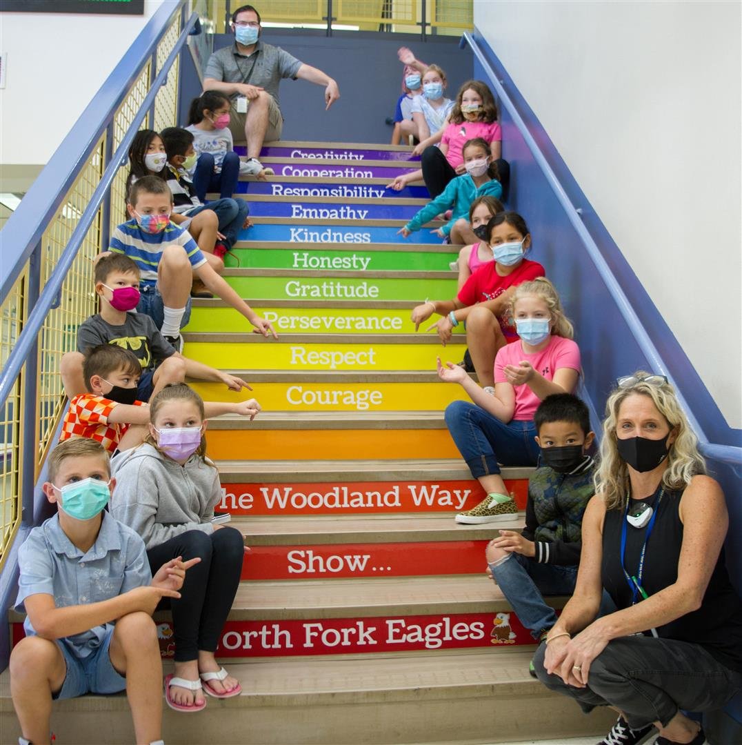 North Fork Elementary School leadership and social-emotional learning teacher Stacia Aschoff sits with her leadership class on the stairs of the school.