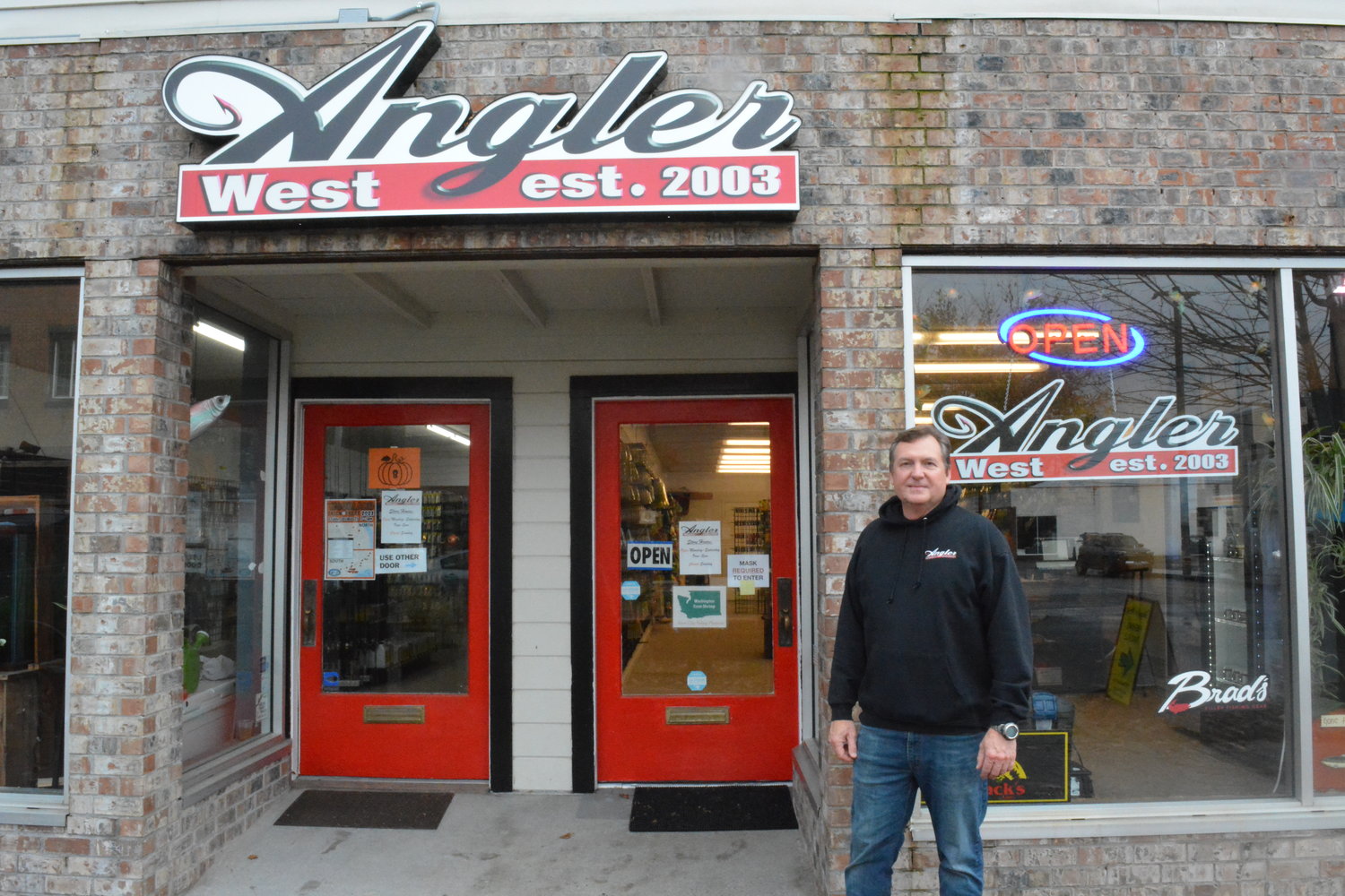 Justin Wolff poses in front of his Angler West tackle shop in Woodland.