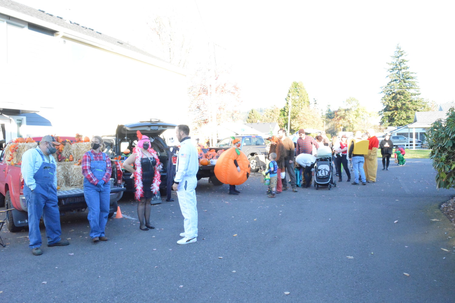 Farmers and a giant pumpkin give out candy to families at the Starting Grounds Church trunk or treat event held on Halloween in Battle Ground.