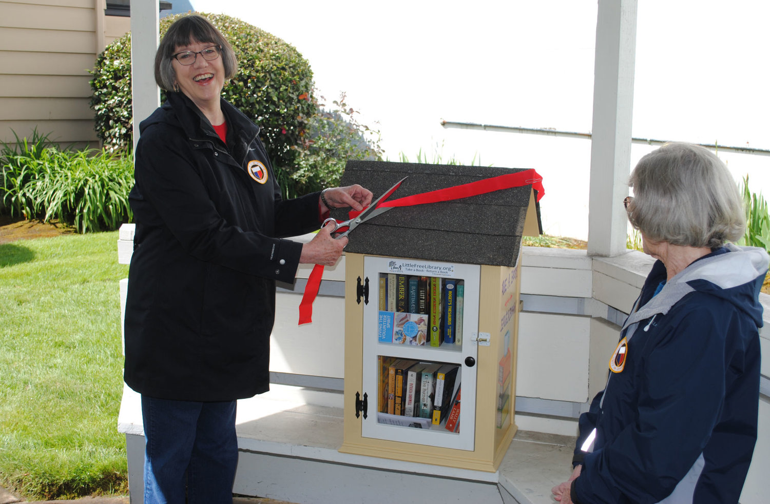 Johanna Hyatt, president of GFWC-Battle Ground, cuts the ribbon on Battle Ground’s first mini-library in 2017.