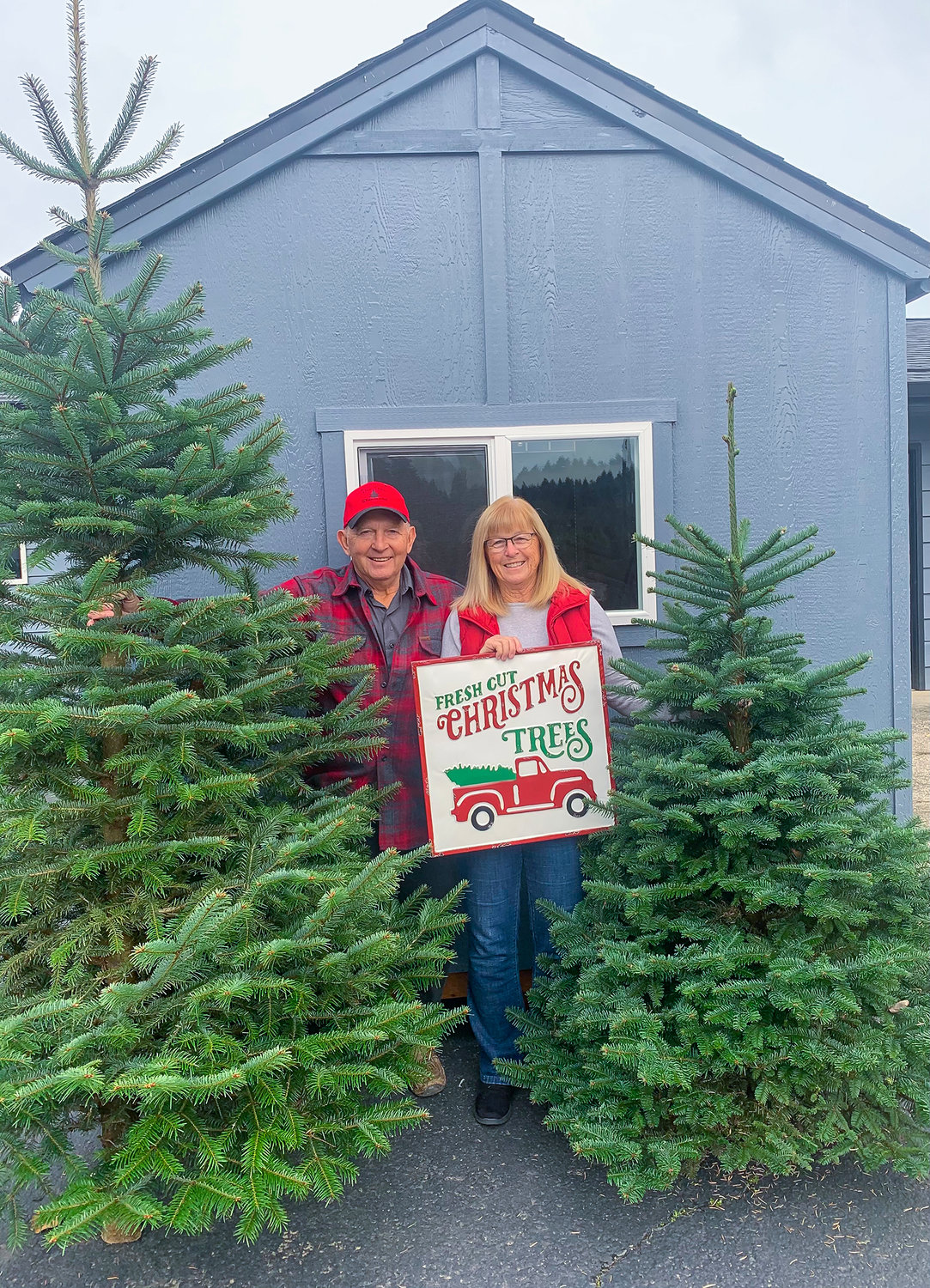 Bruce and Nicki Wiseman stand beside a 25 foot tall Noble fir at The Tree Wisemans in Brush Prairie.