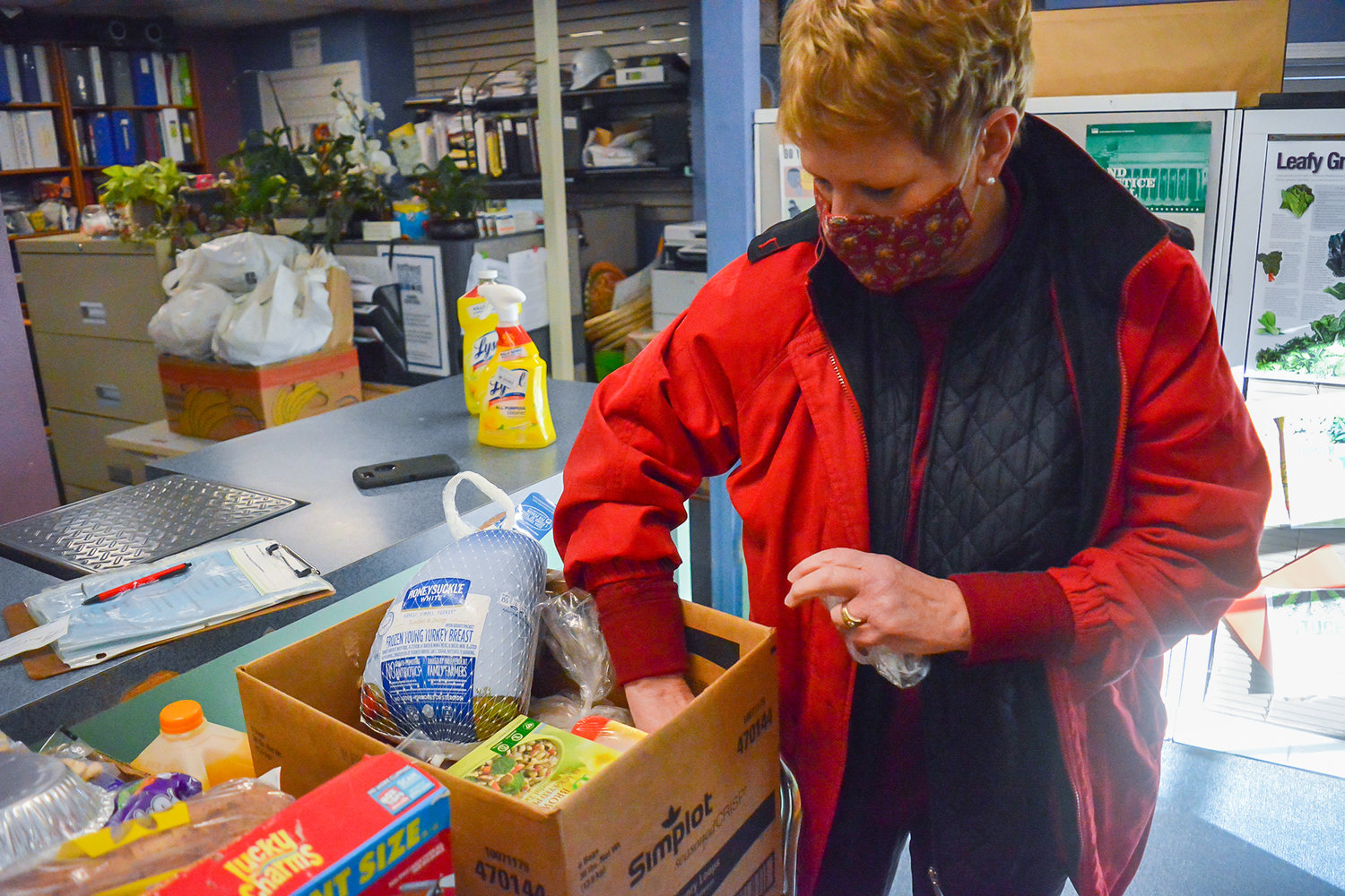 North County Community Food Bank Executive Director Liz Cerveny arranges a Christmas food box.