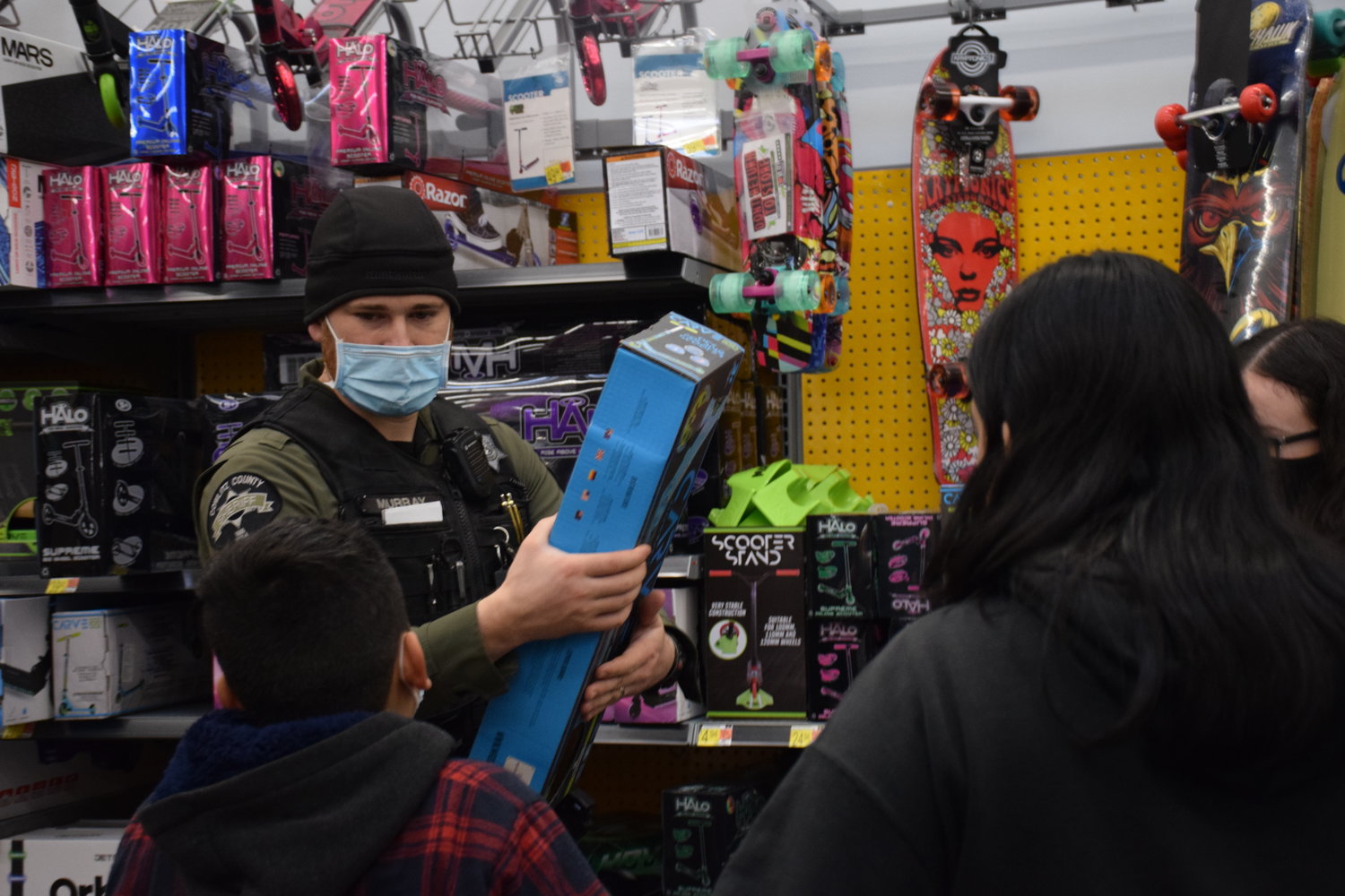 Cowlitz County Sheriff’s deputy Craig Murray consults with Josue Sanchez-Espinal on a scooter during Woodland’s annual Shop With a Cop event on Dec. 11.