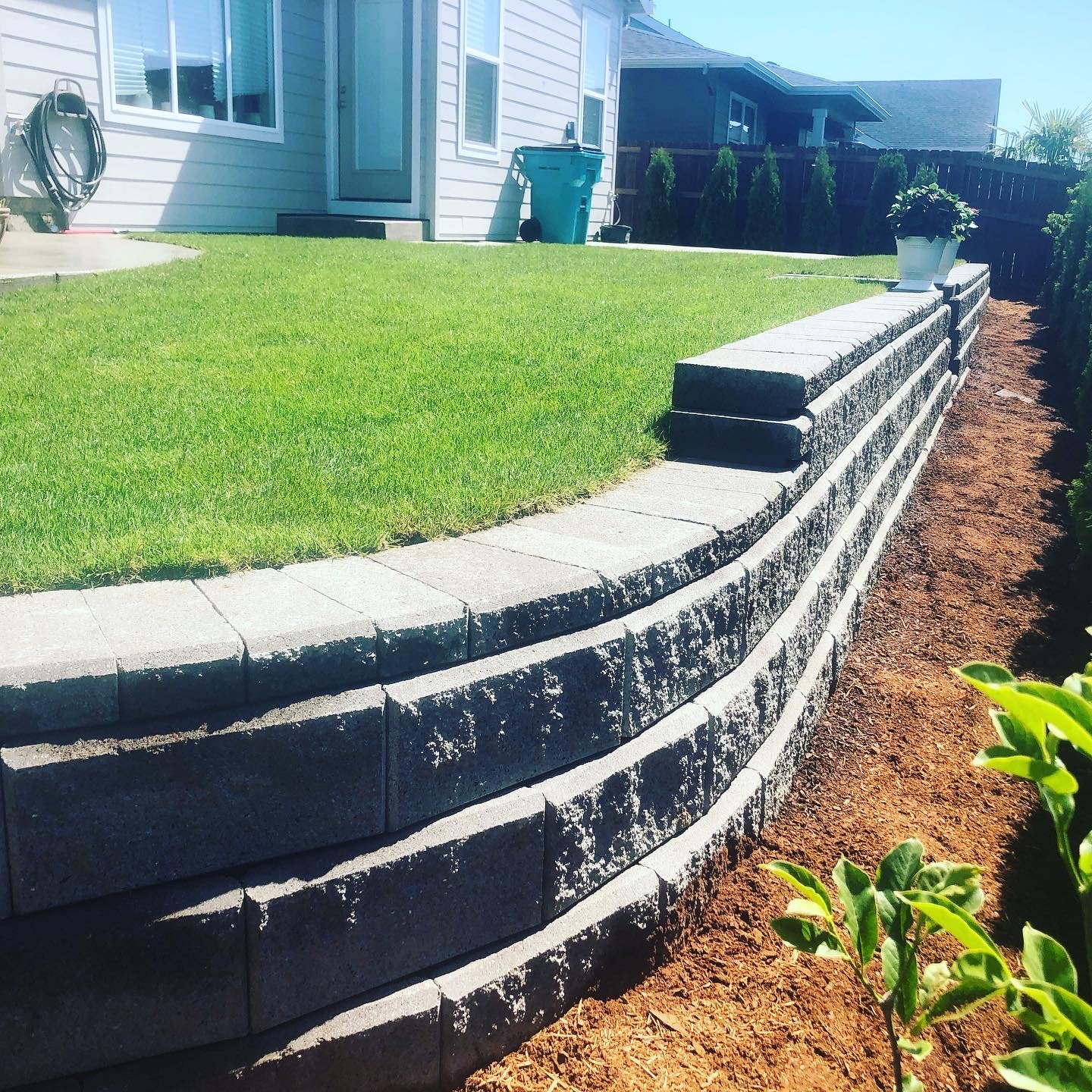 A retaining wall built by All American Landscaping & Maintenance is pictured.