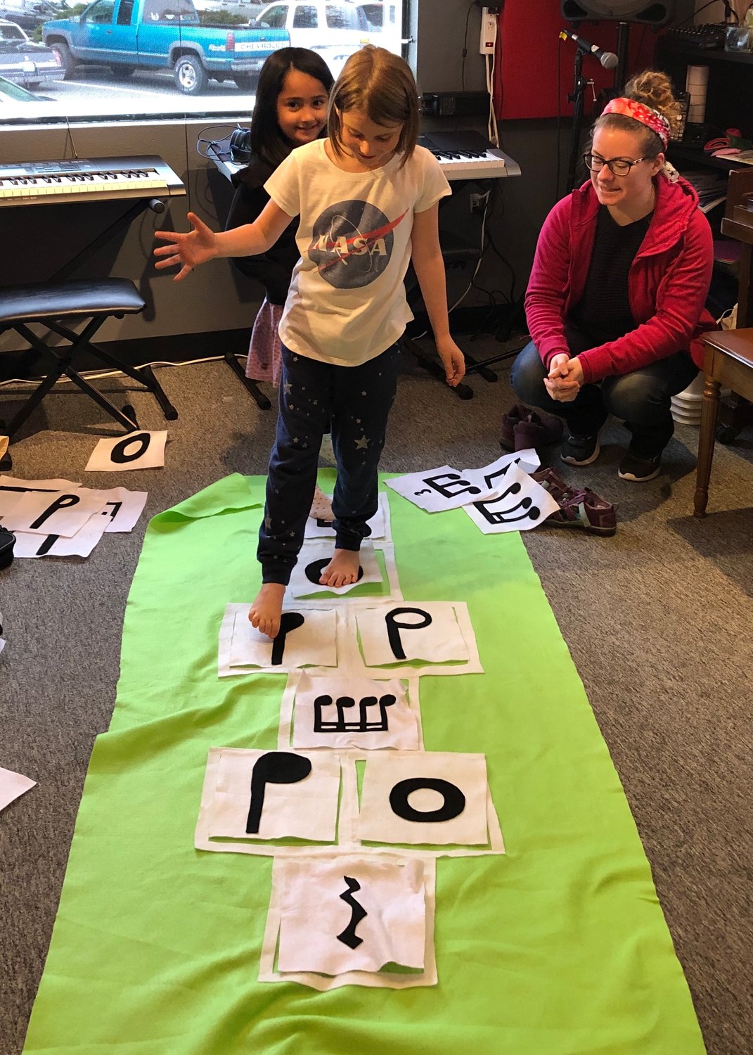 A group of kids play musical hopscotch at The Opus School of Music.