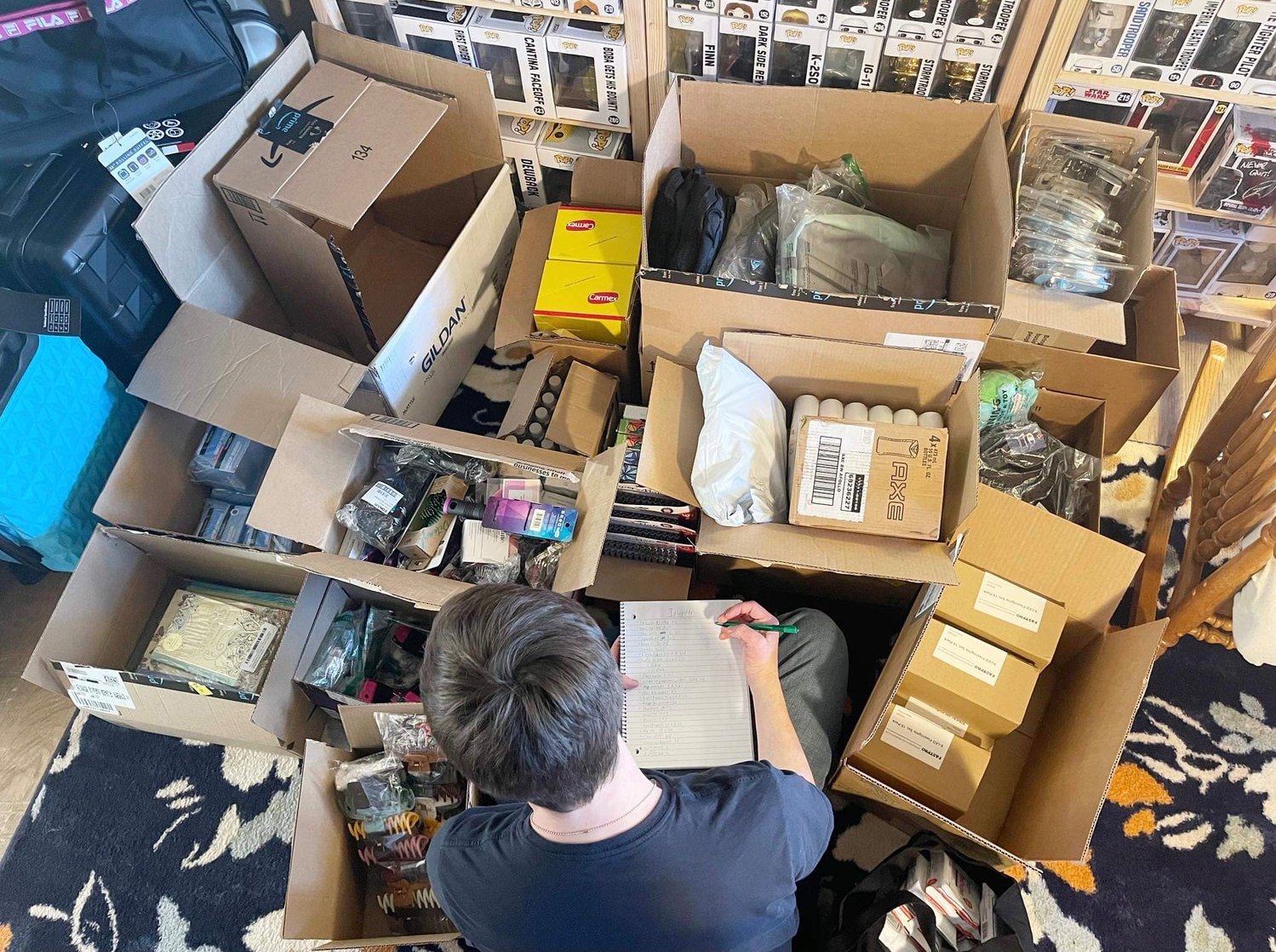Boy Scout Liam McClintock organizes boxes of items collected during a backpack drive that provides supplies for those in the foster care system.