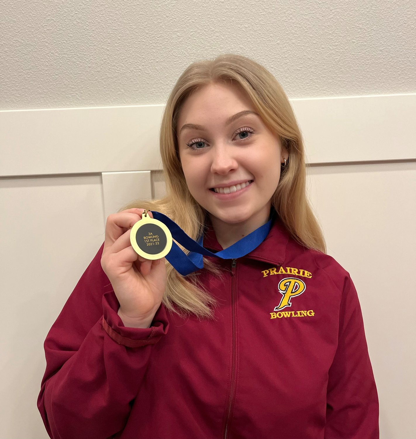 Lilly Bash, a Prairie High School senior, holds her first place medal she earned at the state bowling championship in Tacoma.