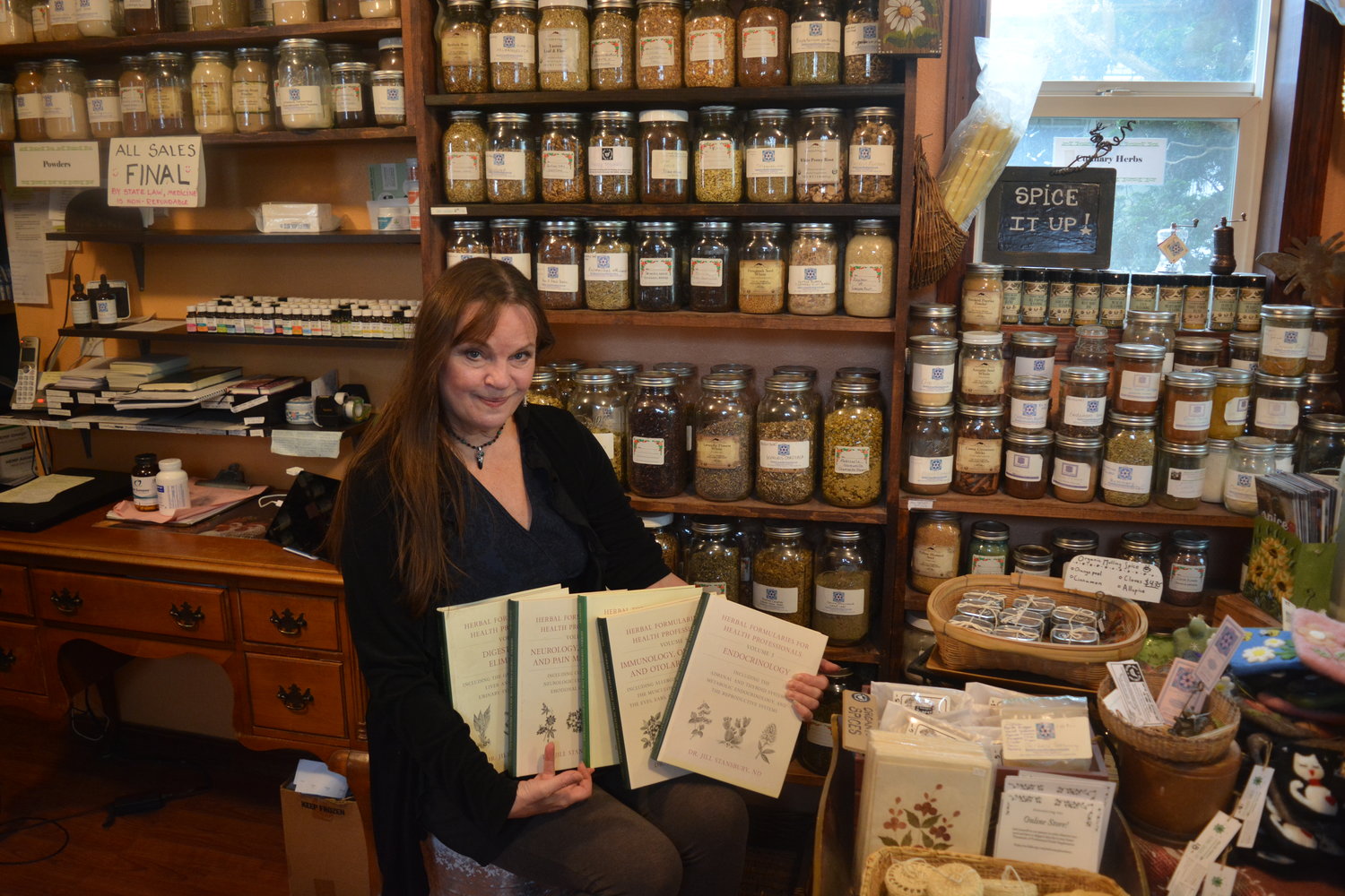 Dr. Jillian Stansbury sits in her apothecary on March 17 at Battle Ground Healing Arts as she holds her Herbal Formularies book series which won the James A. Duke Excellence in Botanical Literature Award.