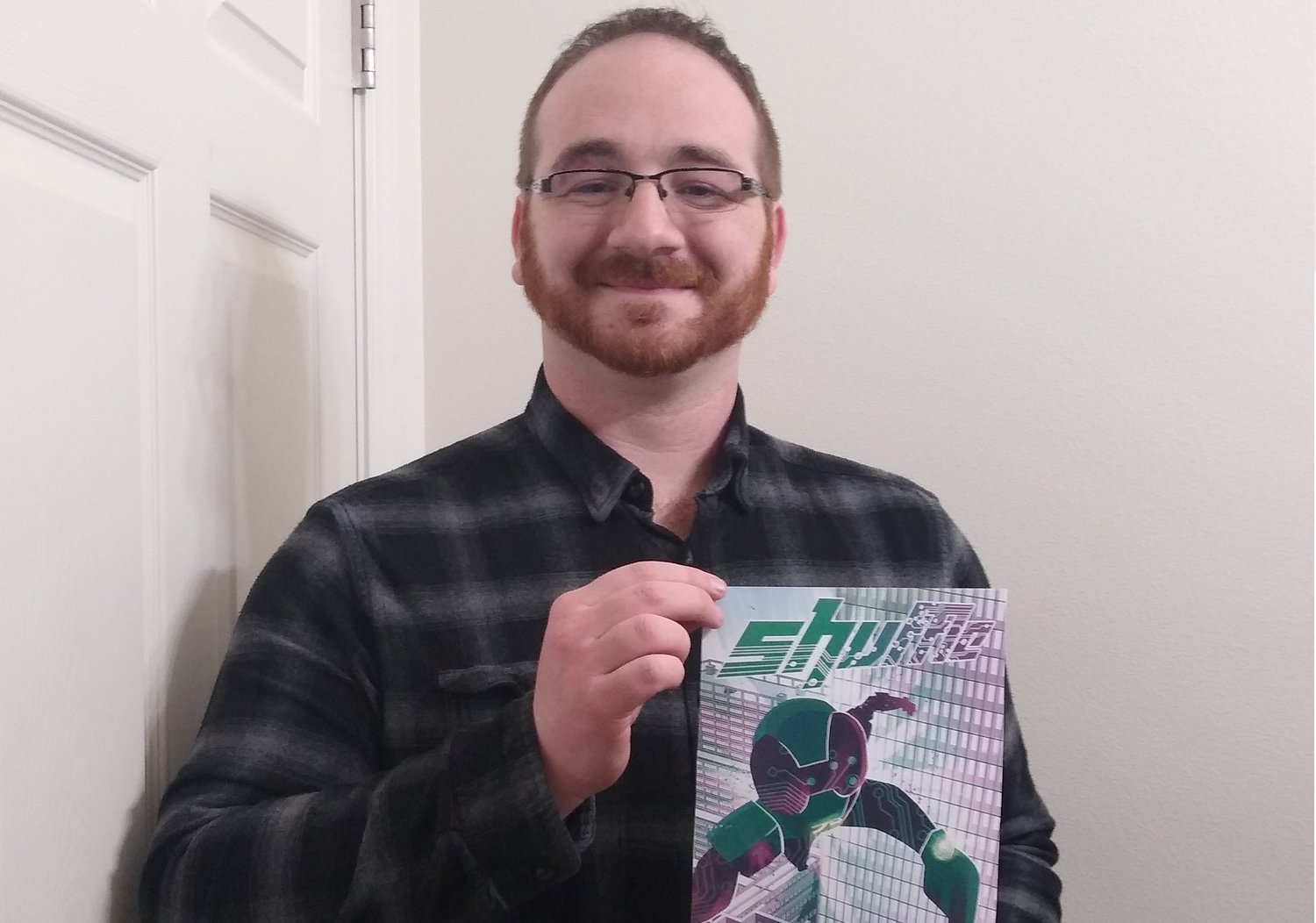 JD Boucher holds a poster of his new comic, Shuffle.