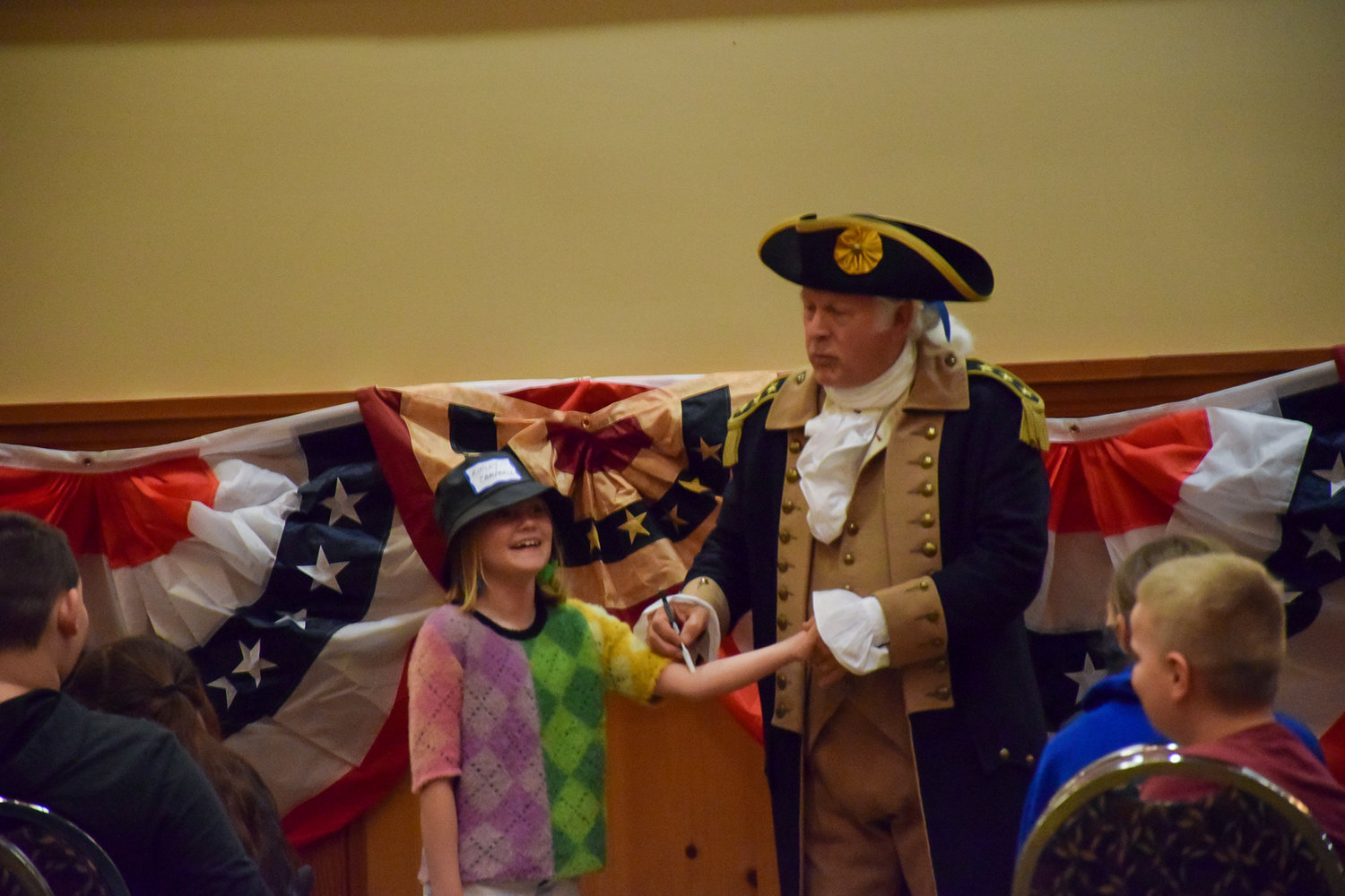 George Washington reenactor Vern Frykholm, with the help of student Kinley Campbell, instructs Tukes Valley Middle School students on medical practices in colonial America during the Sons of the American Revolution convention at the Heathman Lodge on April 9.