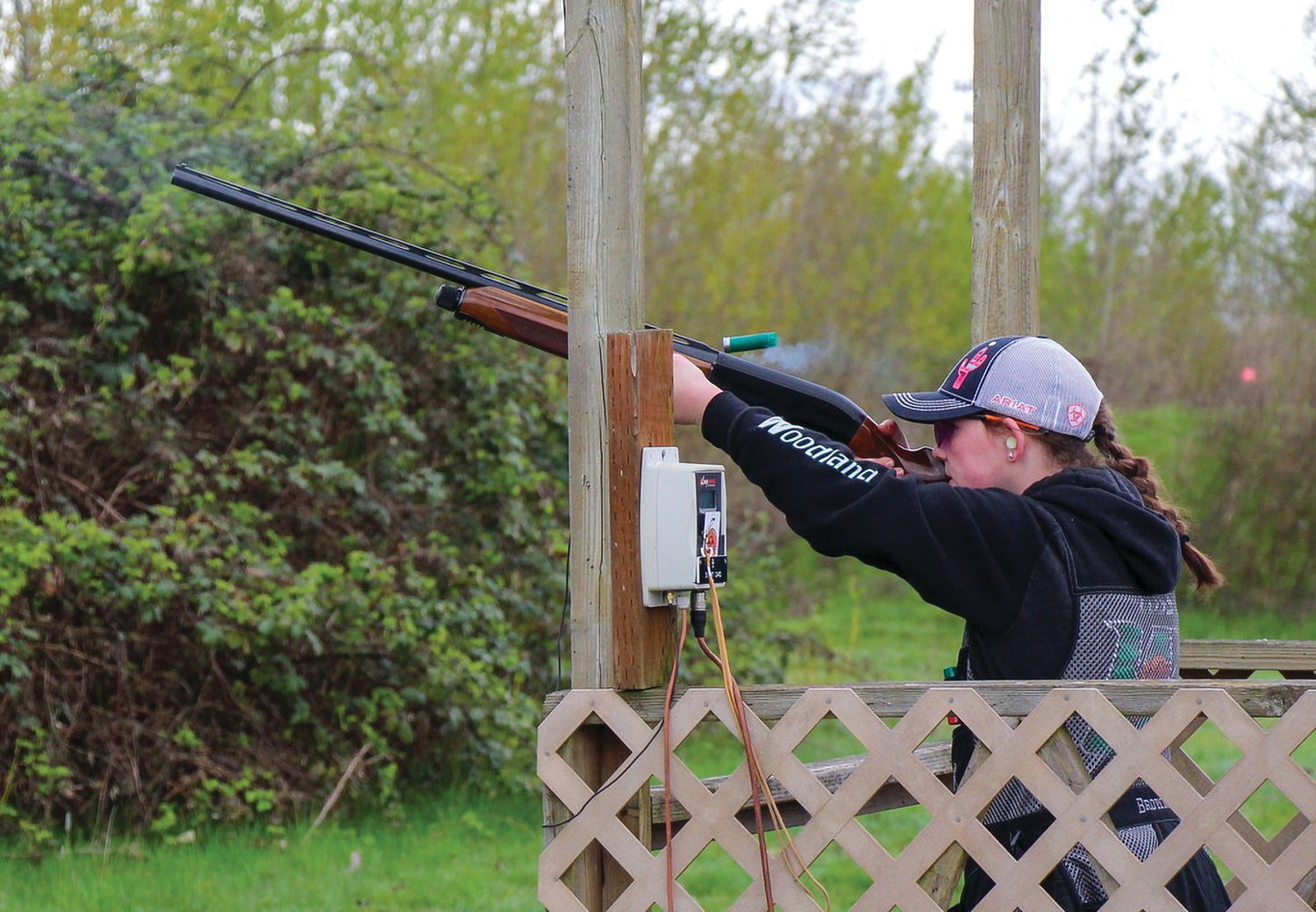 A Woodland High School student shoots an over-under shotgun at a range.