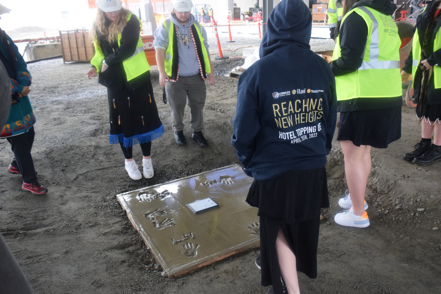 Cowlitz Indian Tribe Youth Council members look at the recently-marked commemorative plaque at the base of the under-construction ilani luxury hotel during a five-year anniversary celebration of the casino resort April 25.