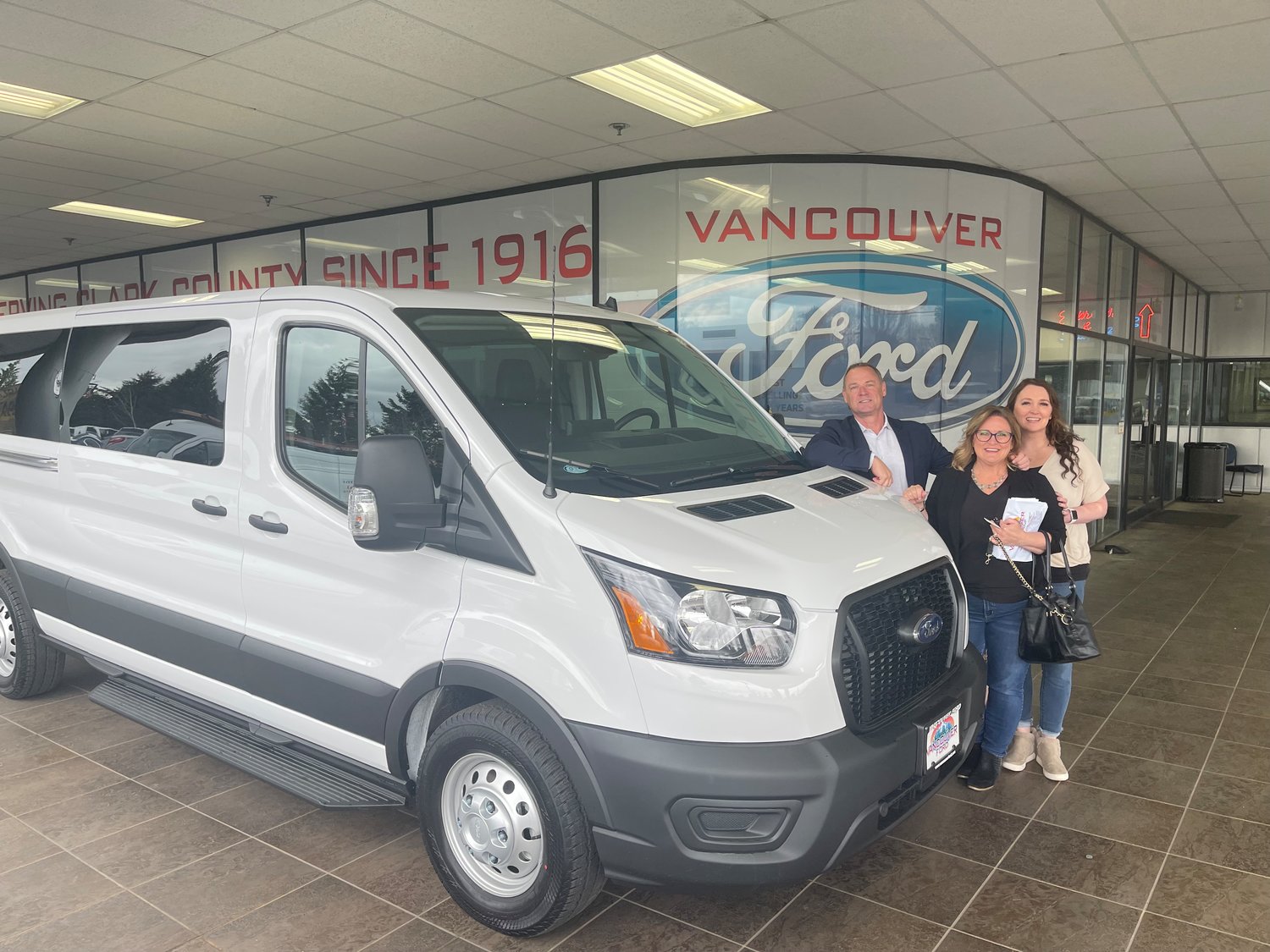 From left to right, Monte Phillips, Marcy Sprecher, and Jessica Rudisill stand next to one of the Rocksolid Teen Community Center’s new vans at Vancouver Ford.