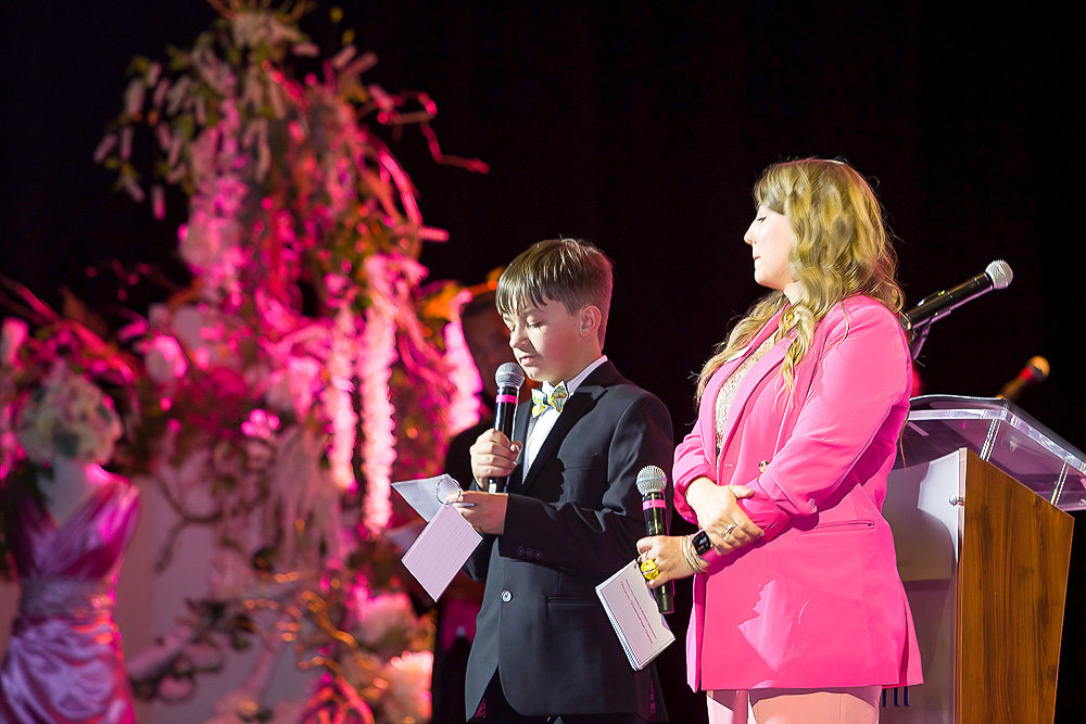 Kristin Stockton, the project manager at Simple Pleasure Events, and her son Charles introduce the $100 special appeal level at the Pink Glow Gala on May 6.