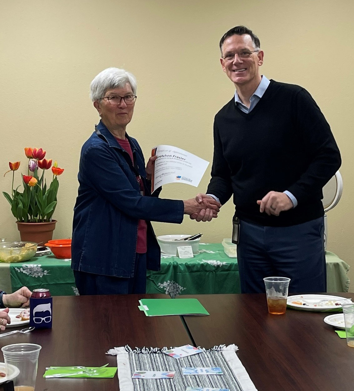 Volunteer Gretchen Frasier receives an award from Mike Reardon, the executive director of the Area Agency on Aging & Disabilities of Southwest Washington, during a SHIBA program volunteer recognition event on April 29.