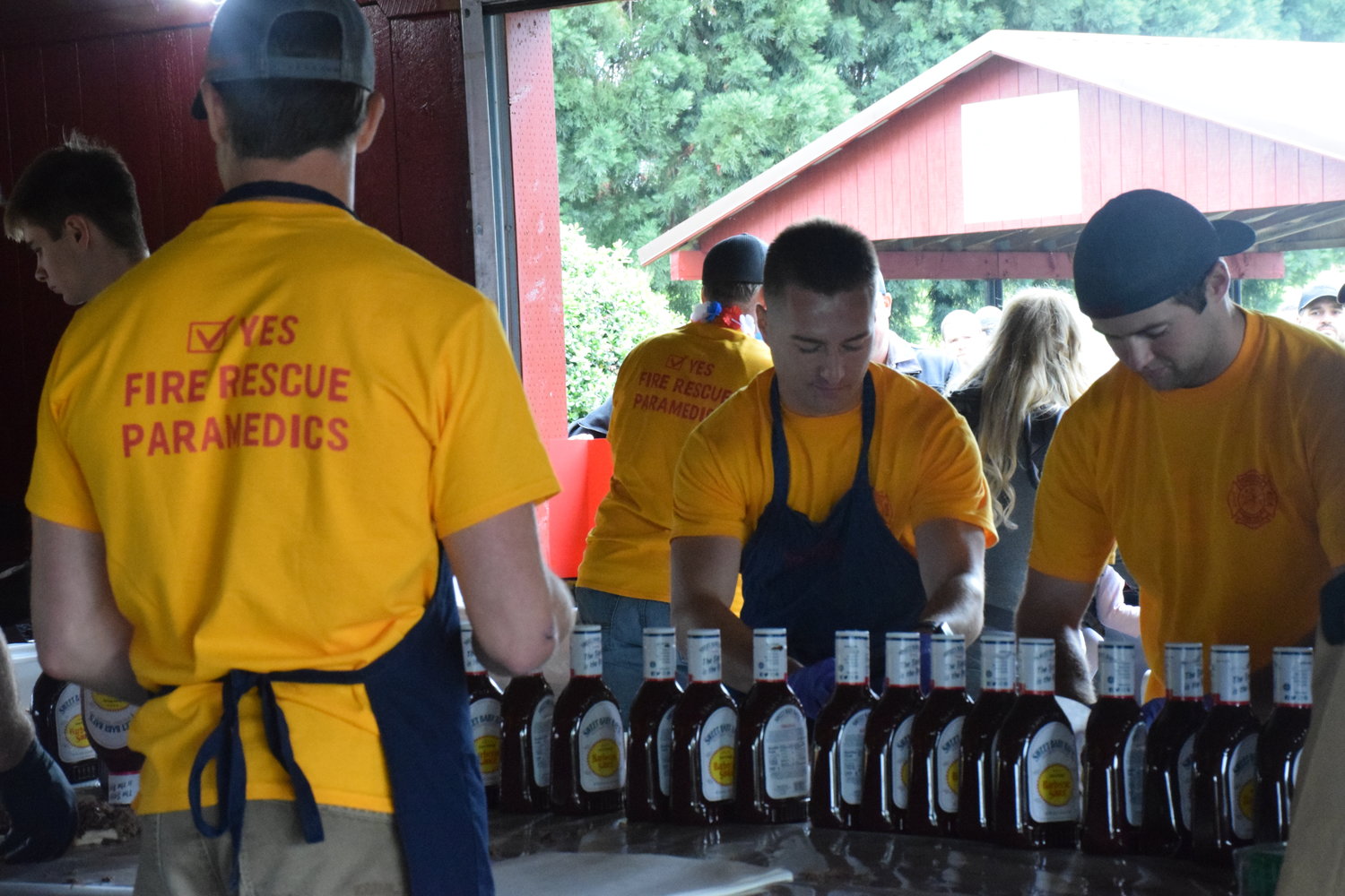 A Clark-Cowlitz Fire Rescue crew prepares to sauce up barbecued meats as part of the firefighters’ association’s annual feed during Woodland’s Planters Days on June 18.