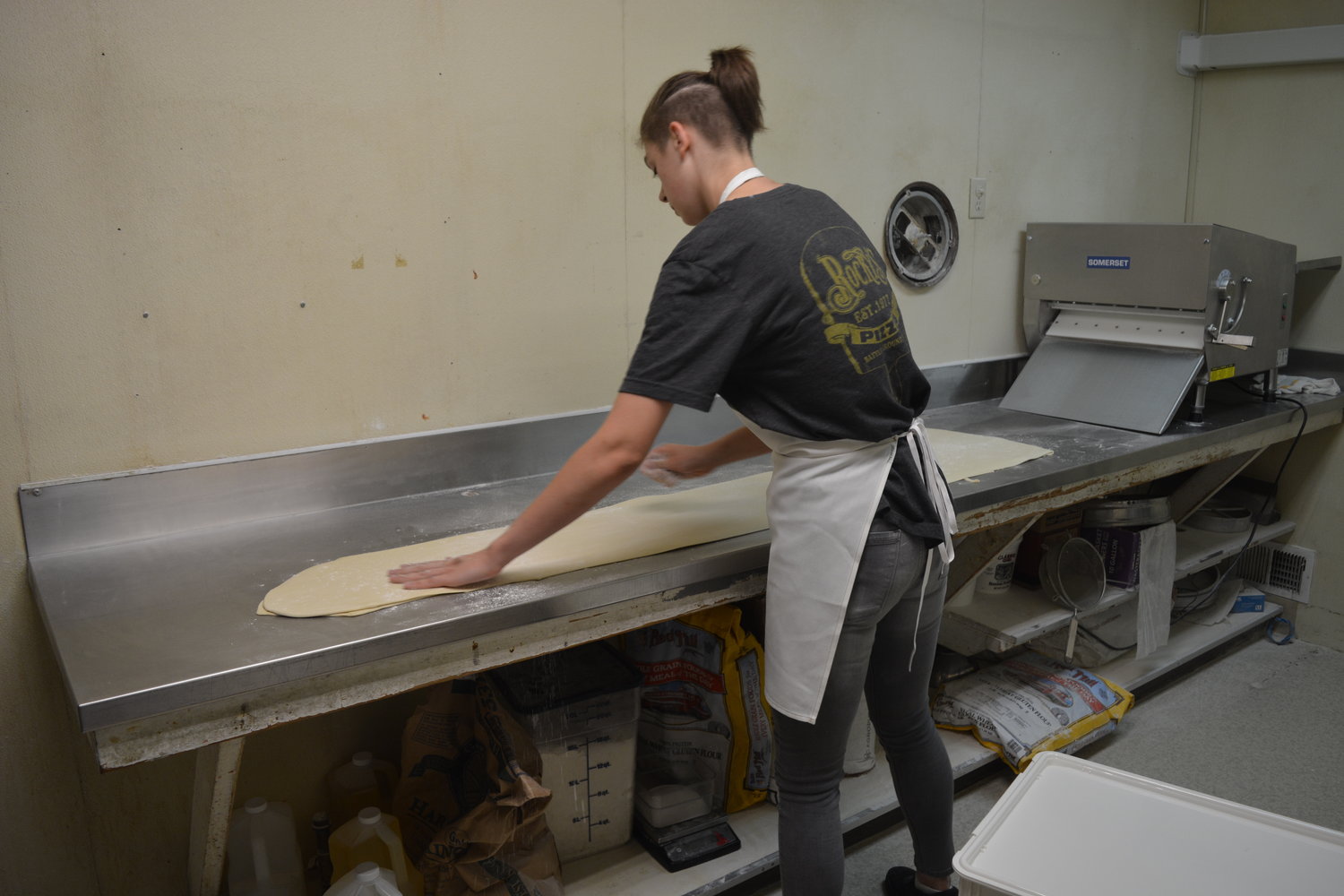 An employee at Rocky’s Pizza & R Bar prepares dough in the back room on July 28.