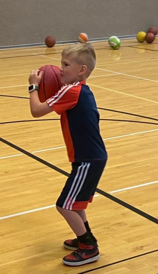 A child gets into position to score a basket at a QuickStart Sports basketball game.
