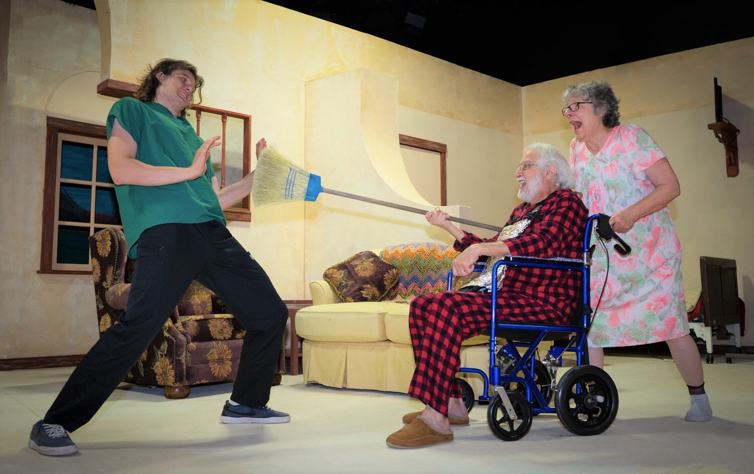 Don Quintero (Christopher Cleveland, middle) and Doris (Carol Radkins, left) engage in mock combat with group home worker Jimmy (Zane Jager, left).