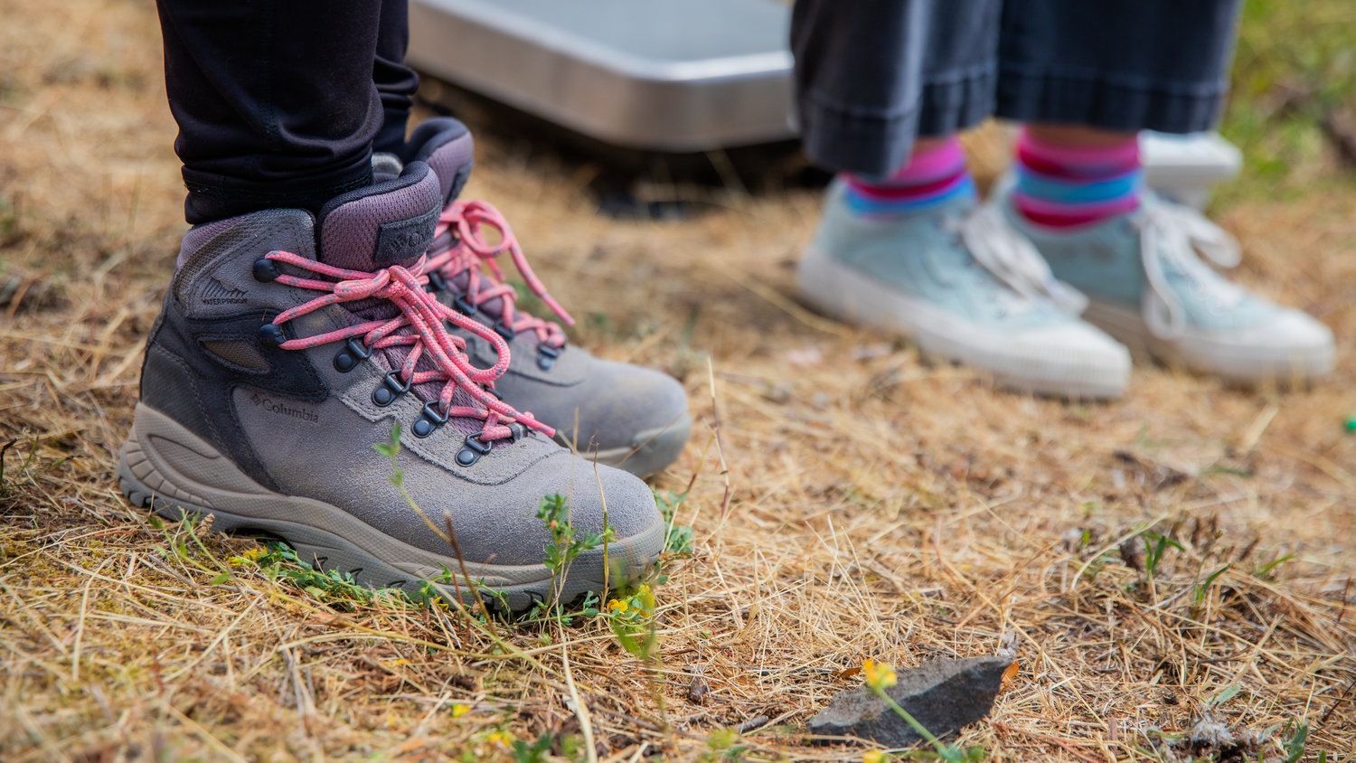 Boots laced in pink and colorful socks are seen on a hillside outside the Mount St. Helens Science and Learning Center at Coldwater as GeoGirls record seismic readings on the slopes.