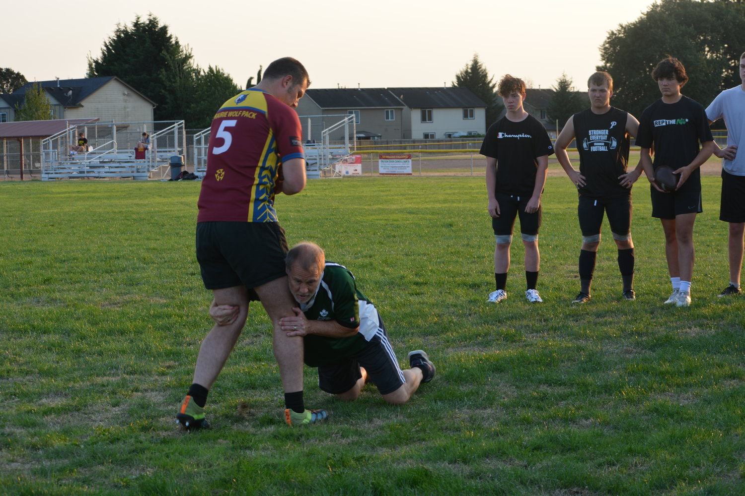 Duffin McShane, the director of coaching development for Chinook Rugby,  demonstrates rugby-style tackling maneuvers at Prairie High School on Aug. 31.