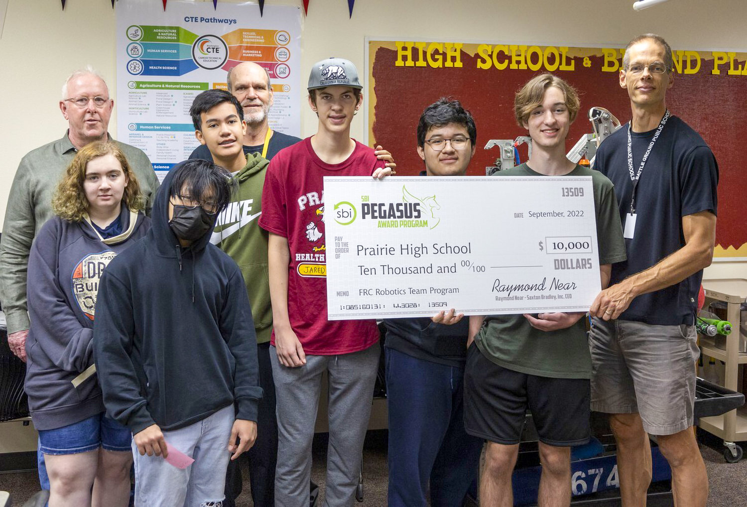 Members of the CloverBots robotics club at Prairie High School stand with a check for a $10,000 grant the program received.