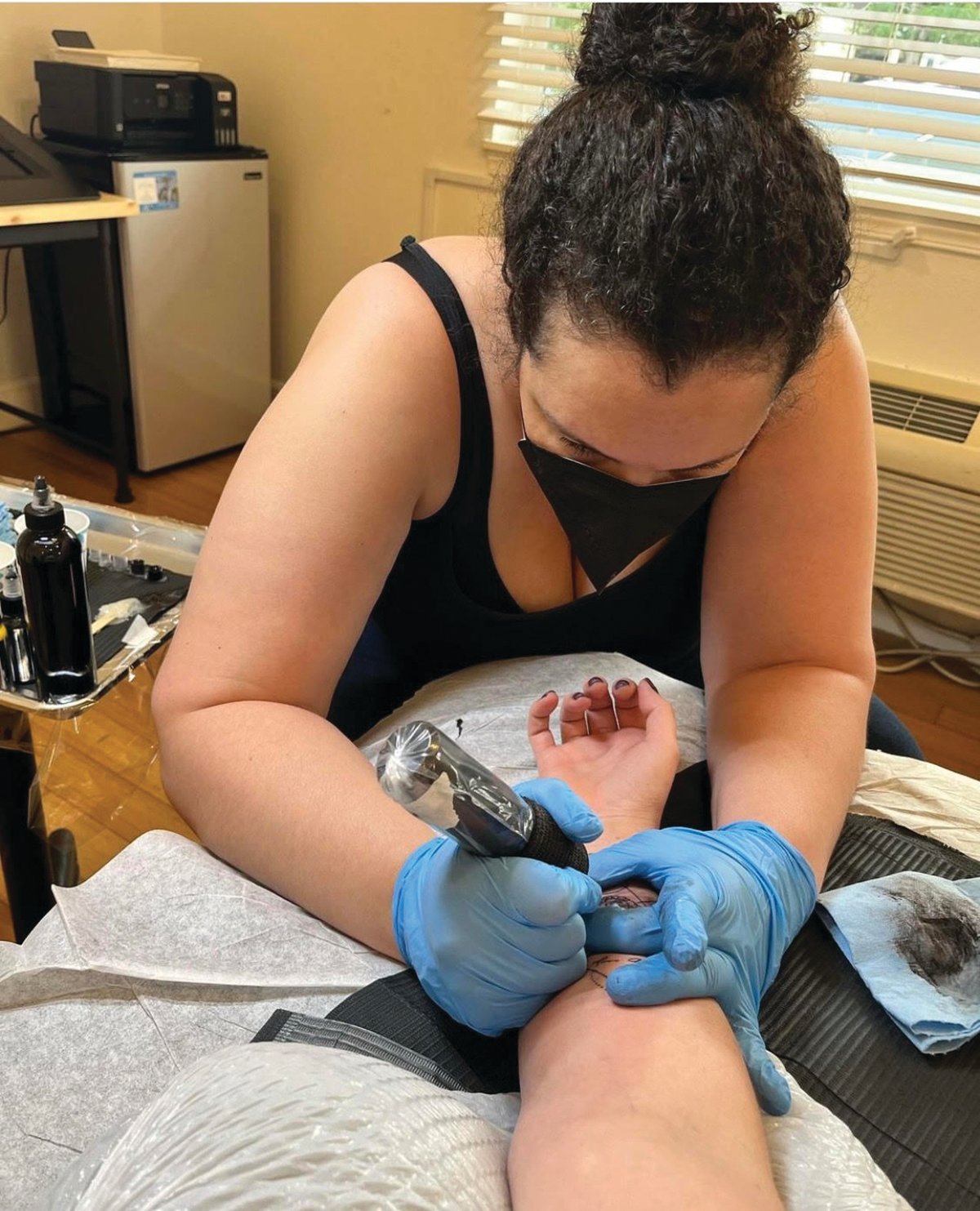 Chelsea Stowers tattoos a client at her studio in Ridgefield.