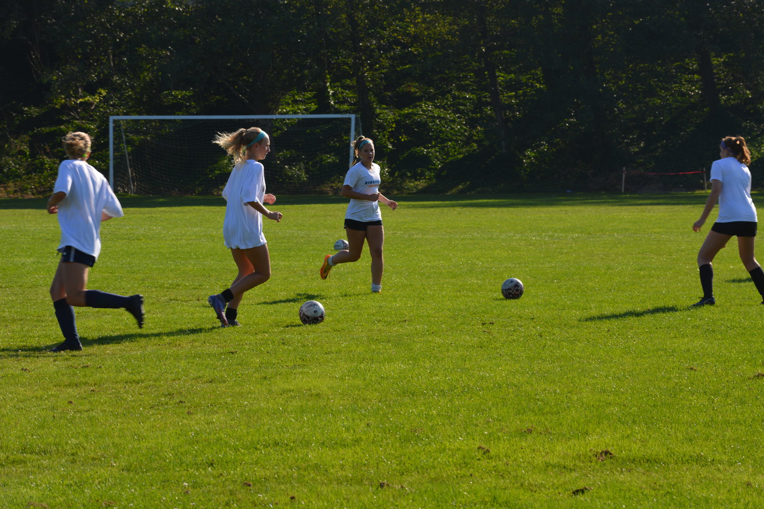 Players from Ridgefield’s girls soccer team gather around the ball during practice on Oct. 5.