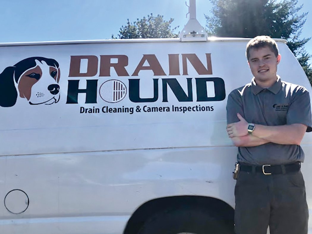 Taylor Prouty stands next to his Drain Hound truck.