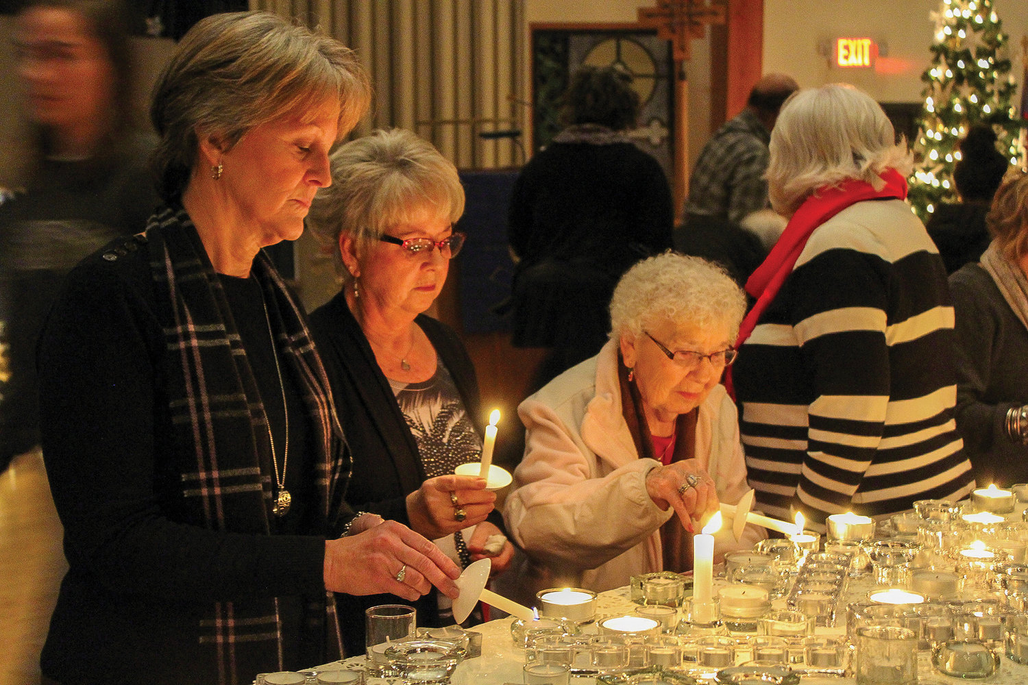 A group of women light candles at a previous longest night service at St. John Lutheran Church.
