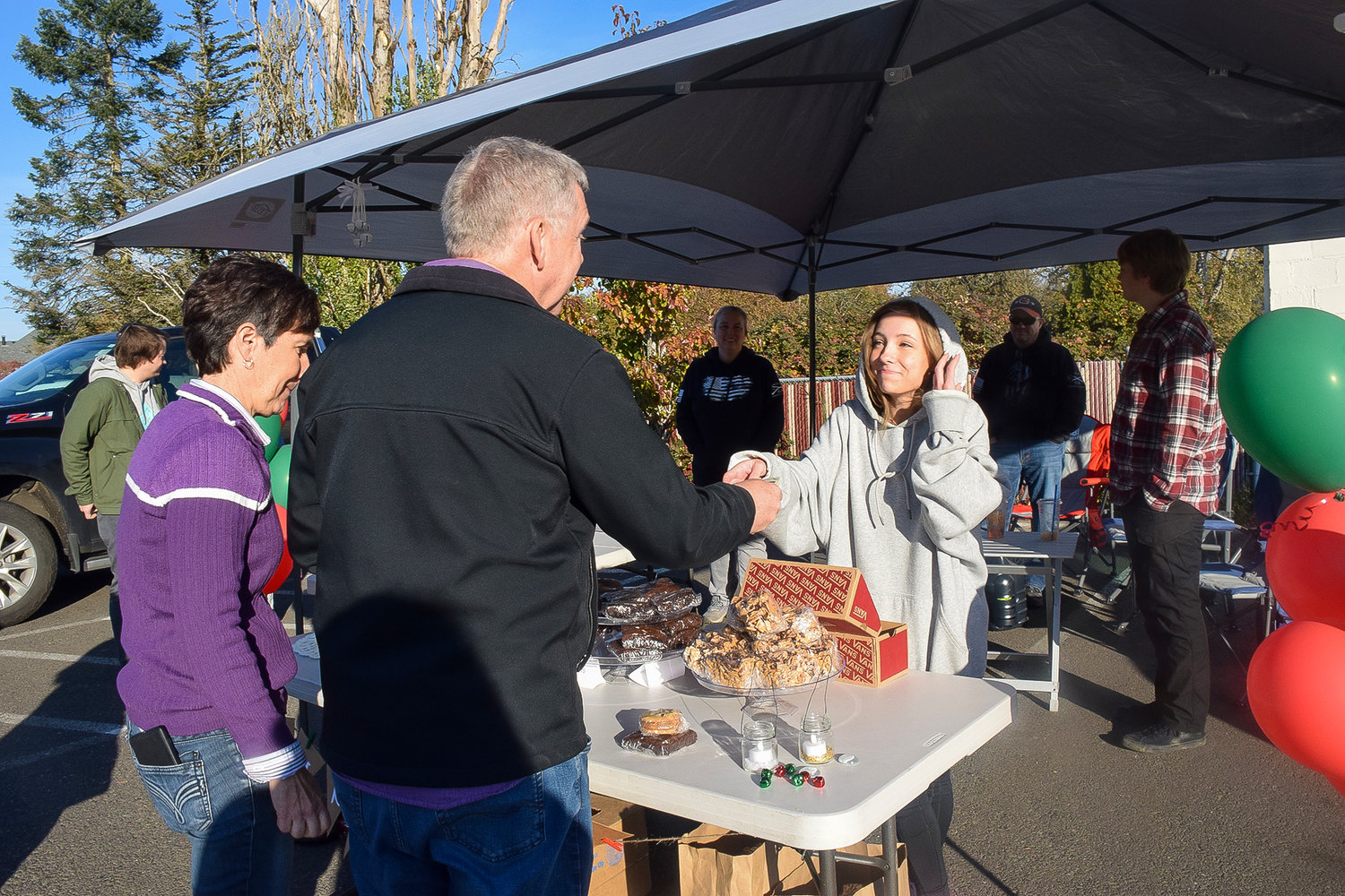 Battle Ground teen Hannah Boyett makes a sale at her fundraiser to support a family in need in the parking lot of the Margarita Factory on Nov. 20.
