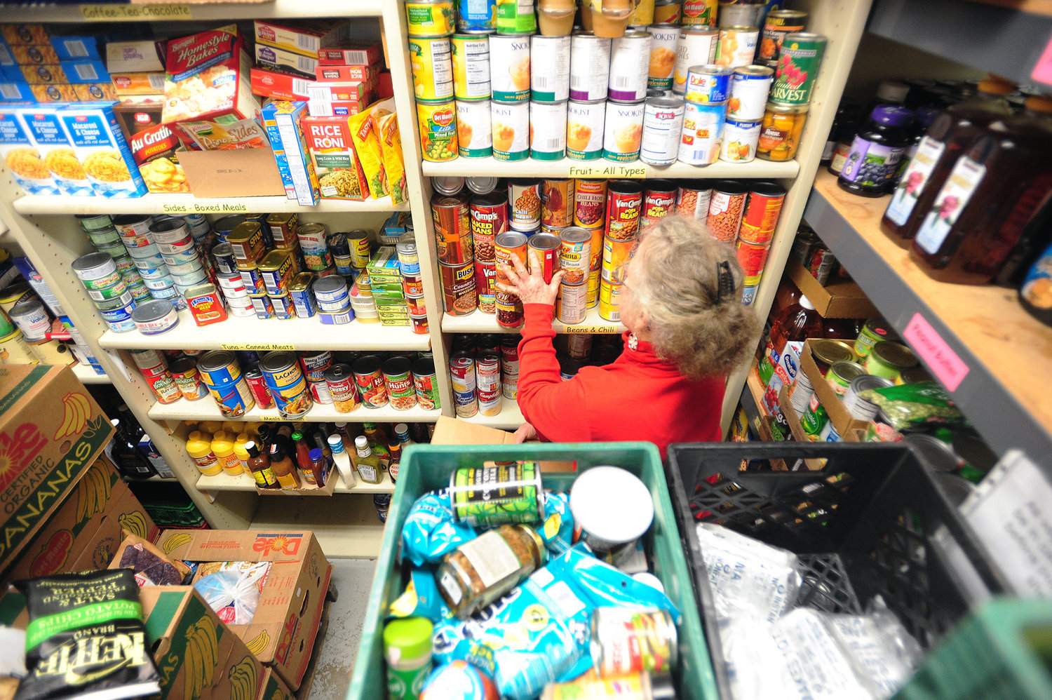 A volunteer sorts through donated food items in this file photo. Walk and Knock, a one-day food drive scheduled for Dec. 3, typically collects between 250,000 and 300,000 pounds of food annually, which is then donated to the Clark County Food Bank.