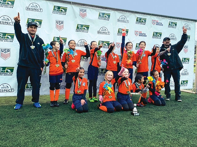 The Ridgefield Avalanche U11 soccer team for Pacific Soccer Club poses with the trophy from the Washington Youth Soccer Recreational Cup.