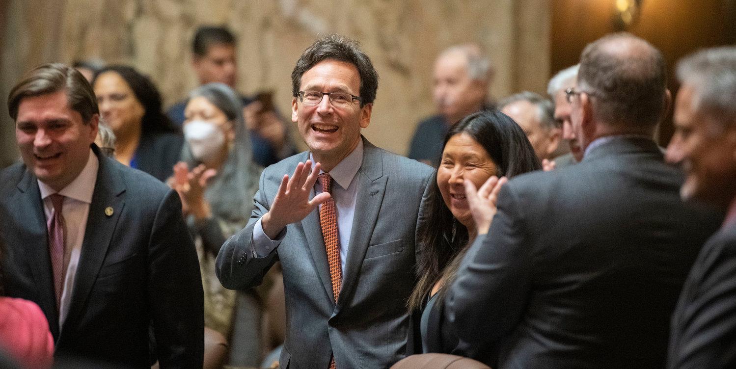 Washington state Attorney General Bob Ferguson smiles and waves as he enters the House Chambers in Olympia on Tuesday prior to the beginning of the 2023 State of the State speech.