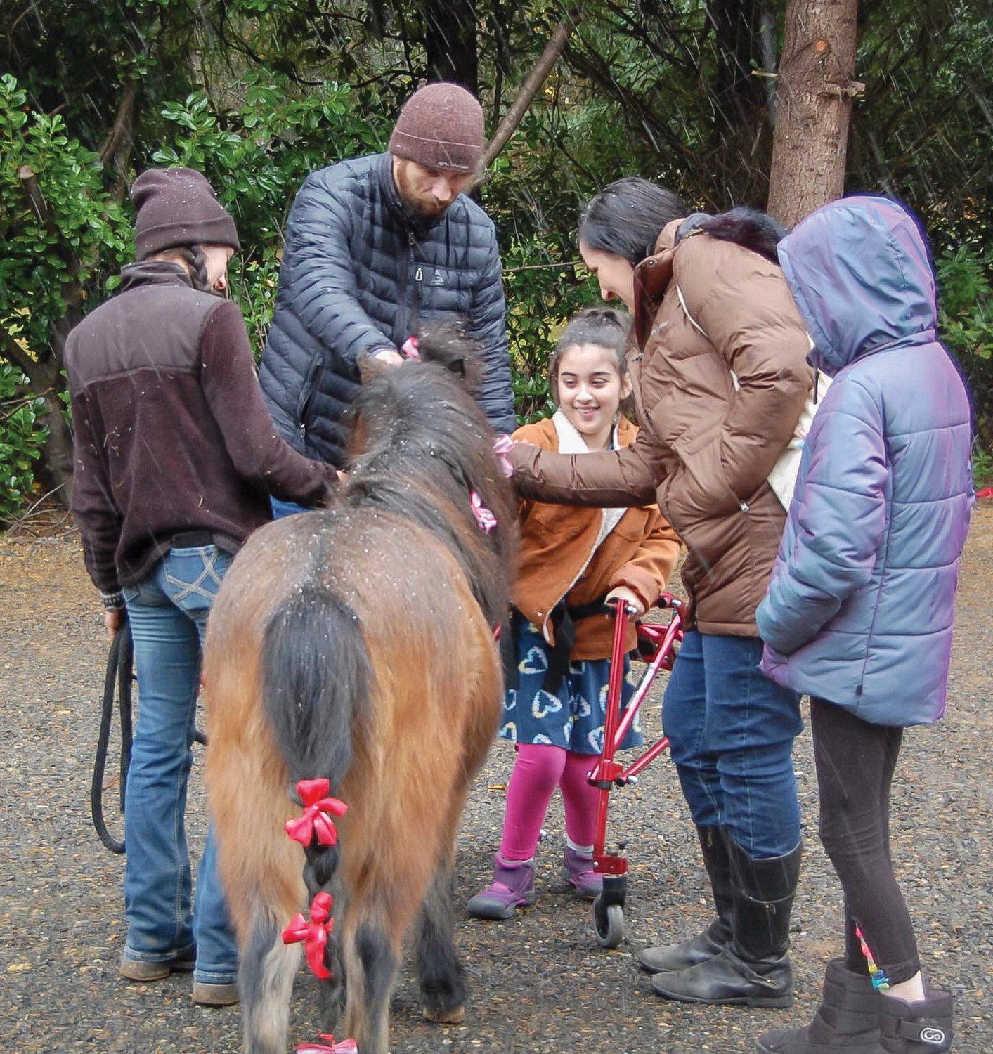 TEAM High School teacher Elizabeth Vallaire and daughter Harper pet a horse at Healing Steps where Harper receives occupational therapy.