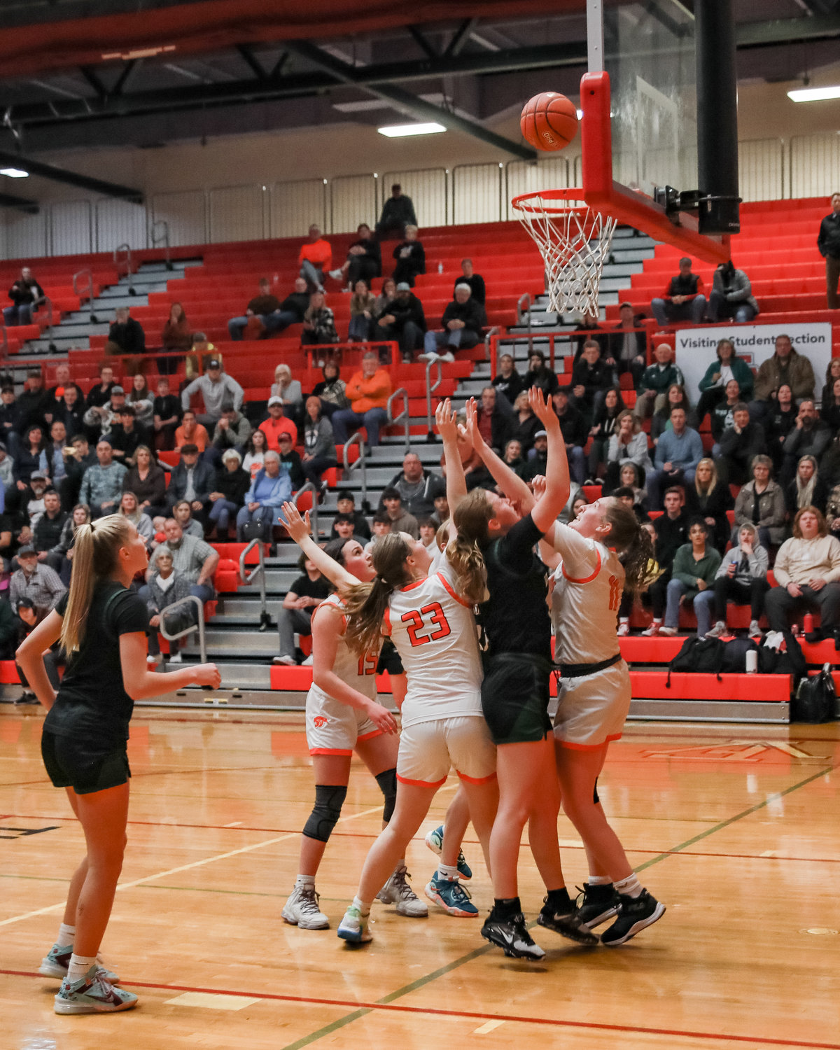 Emily Hughes of Woodland makes a basket as a swarm of Washougal players cover her during a district matchup game on Monday, Feb. 13. 