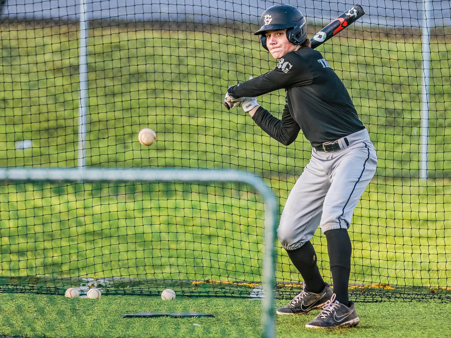 Peyton Sanders of the Tigers eyes up a baseball in the outdoor batting cages at the Battle Ground High School baseball fields on Wednesday, March 8.