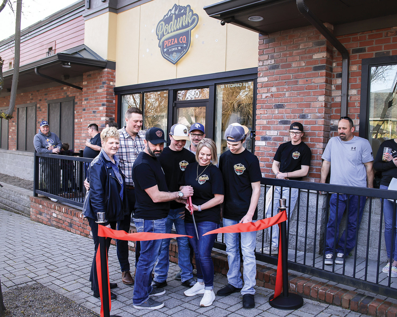 The ribbon at Podunk Pizza Co. is cut by owners Tosha and Anthony Emerson, a husband and wife duo, during the grand opening event for the business in La Center on Saturday, March 18.