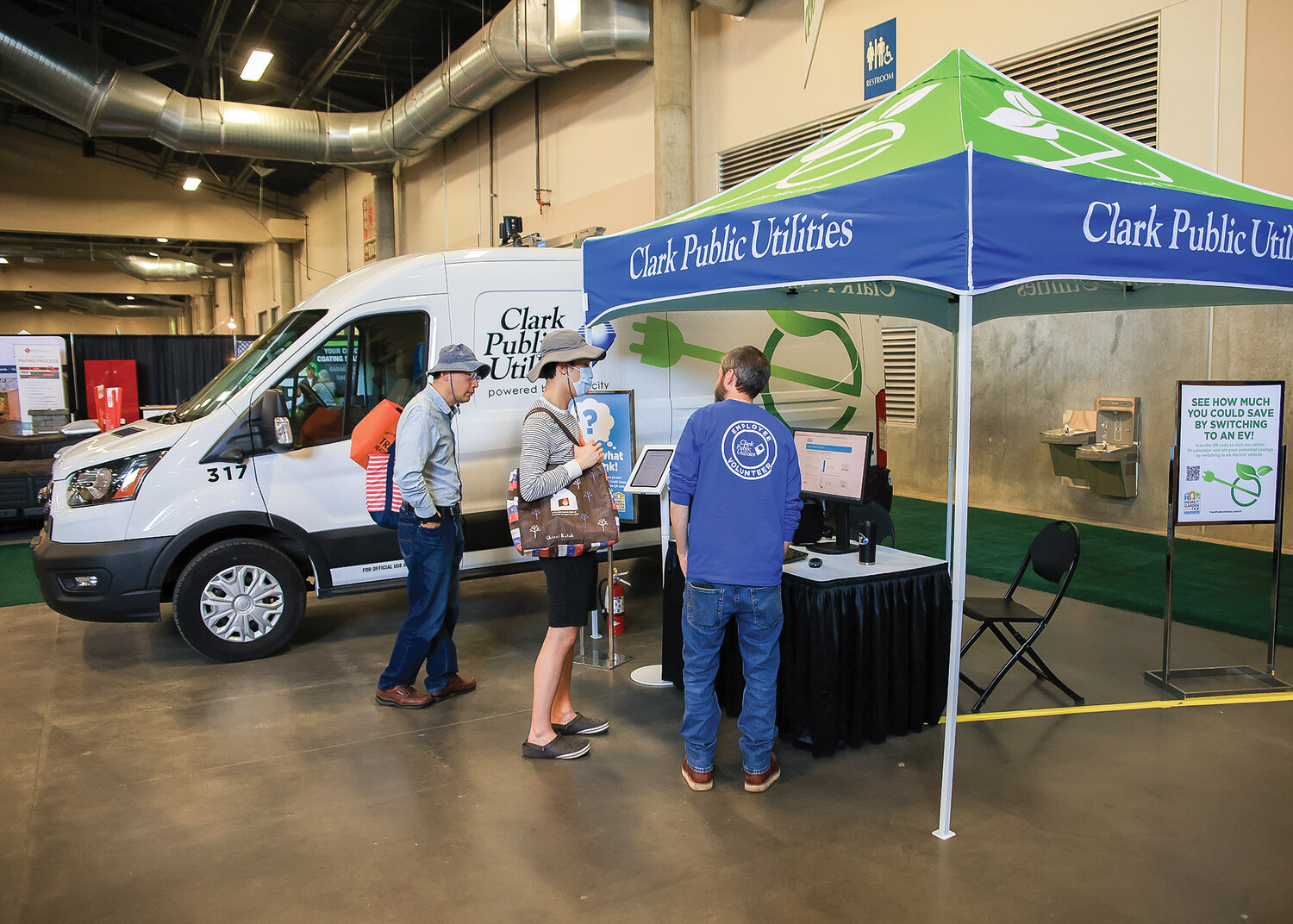 A Clark Public Utilities employee educates people about electric vehicles and at home charging stations at the Home and Garden Idea Fair in Ridgefield on Saturday, April 29. In the background is a fully electric work van that CPU utilizes.
