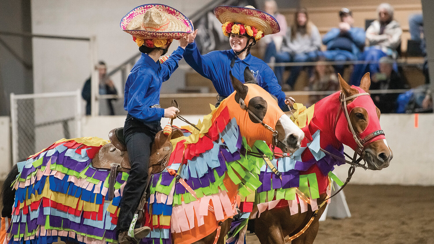 Hockinson riders Allison Domingos, left, and Jewel Atchley high-five after finishing a performance to “La Bamba” in Tacoma on Saturday, April 15 for the team’s final district meet of the season.